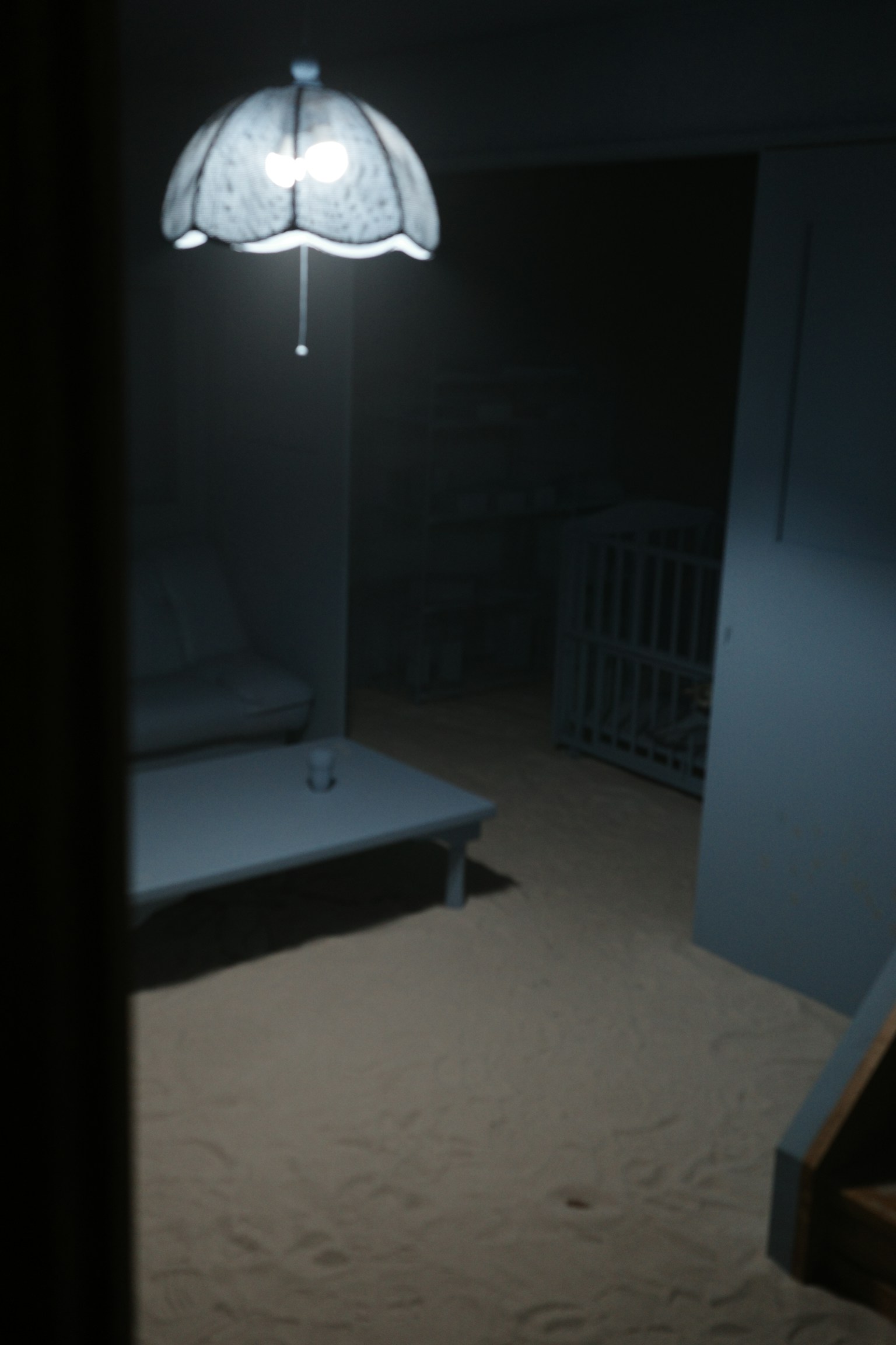 Una lámpara iluminando un sofá y una mesa en una habitación de arena azul