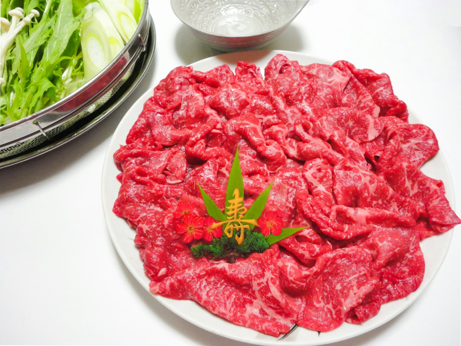 Piatto di manzo affettato finemente con verdure fresche in una ciotola