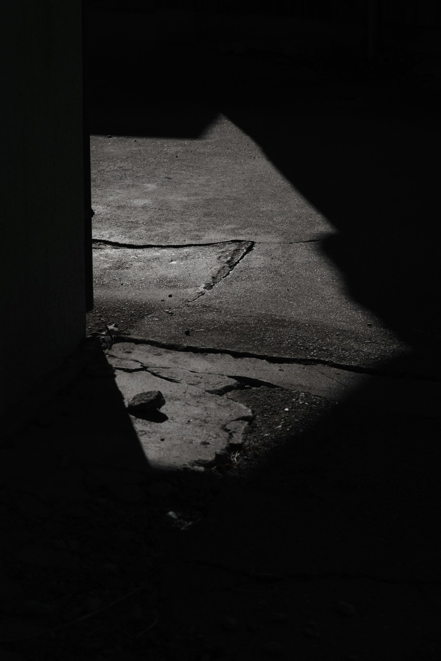 Contrast of shadow and light on a concrete floor in a dark setting
