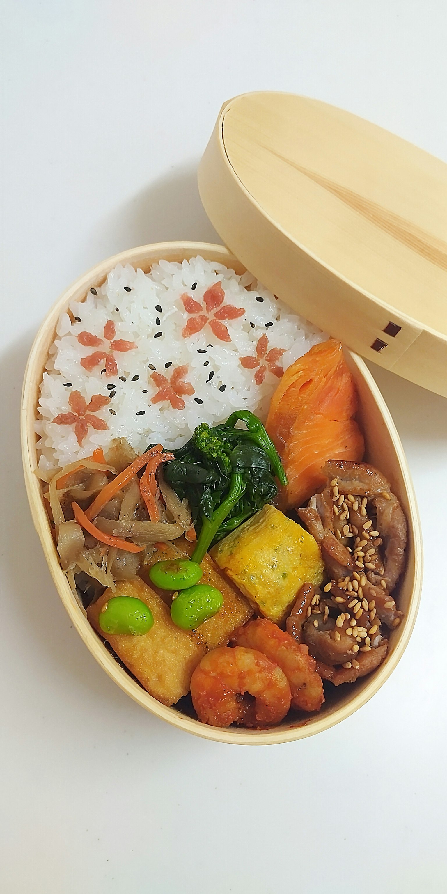 Kotak bento yang diatur dengan indah dengan bahan berwarna-warni