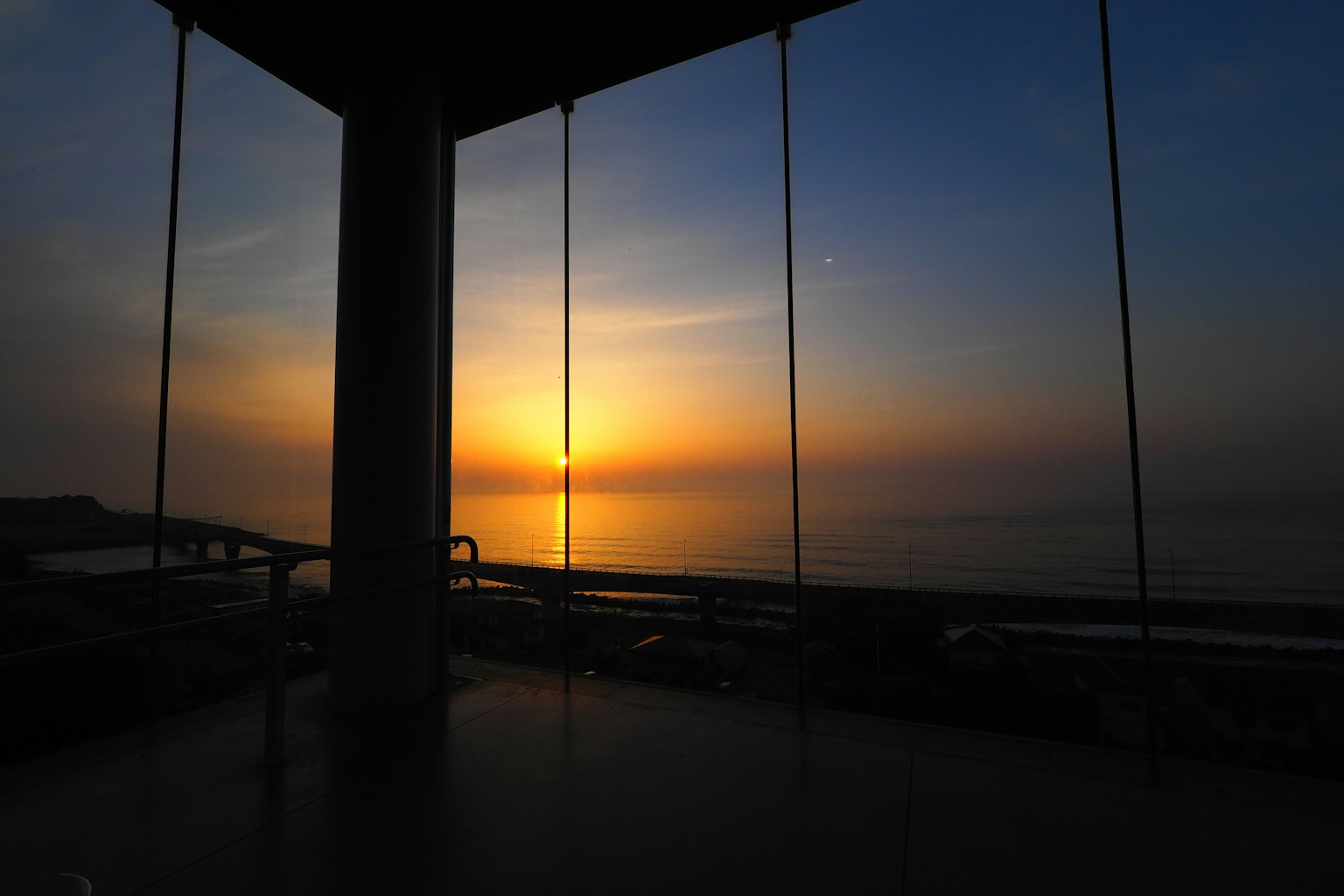Silhouette of a building with a beautiful sunset over the sea
