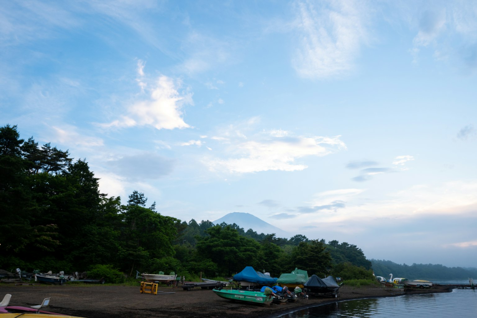 산과 호수의 경치와 캠핑장 및 카약이 보인다