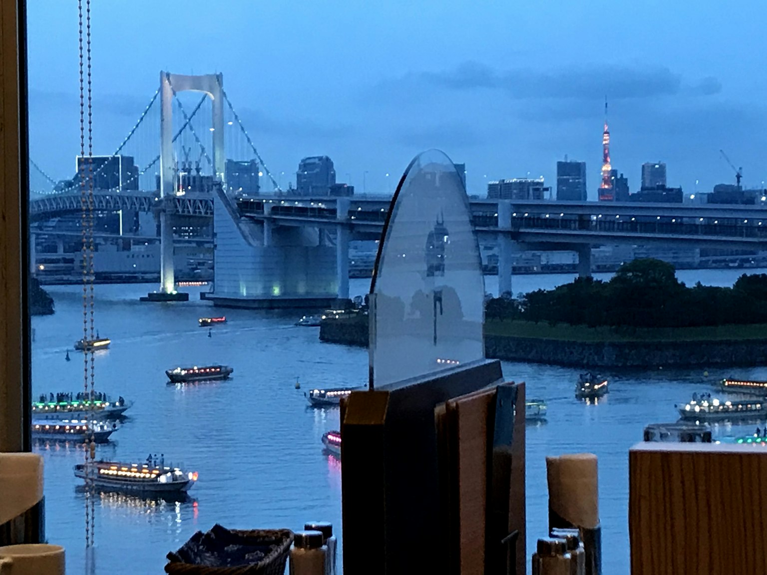 Vue nocturne du pont Rainbow et de la tour de Tokyo avec des bateaux sur la rivière