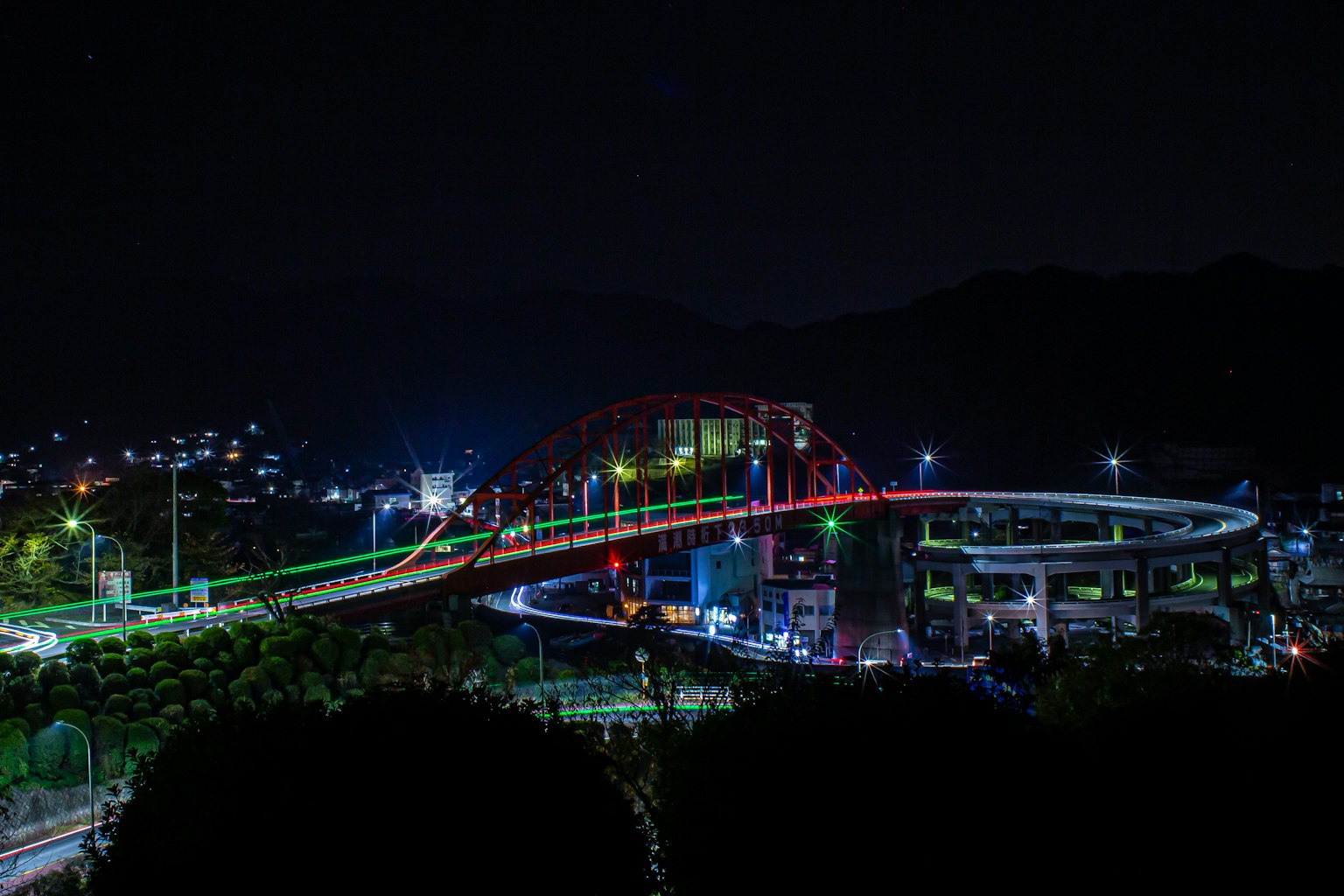 Vue nocturne d'un pont coloré et d'un paysage urbain