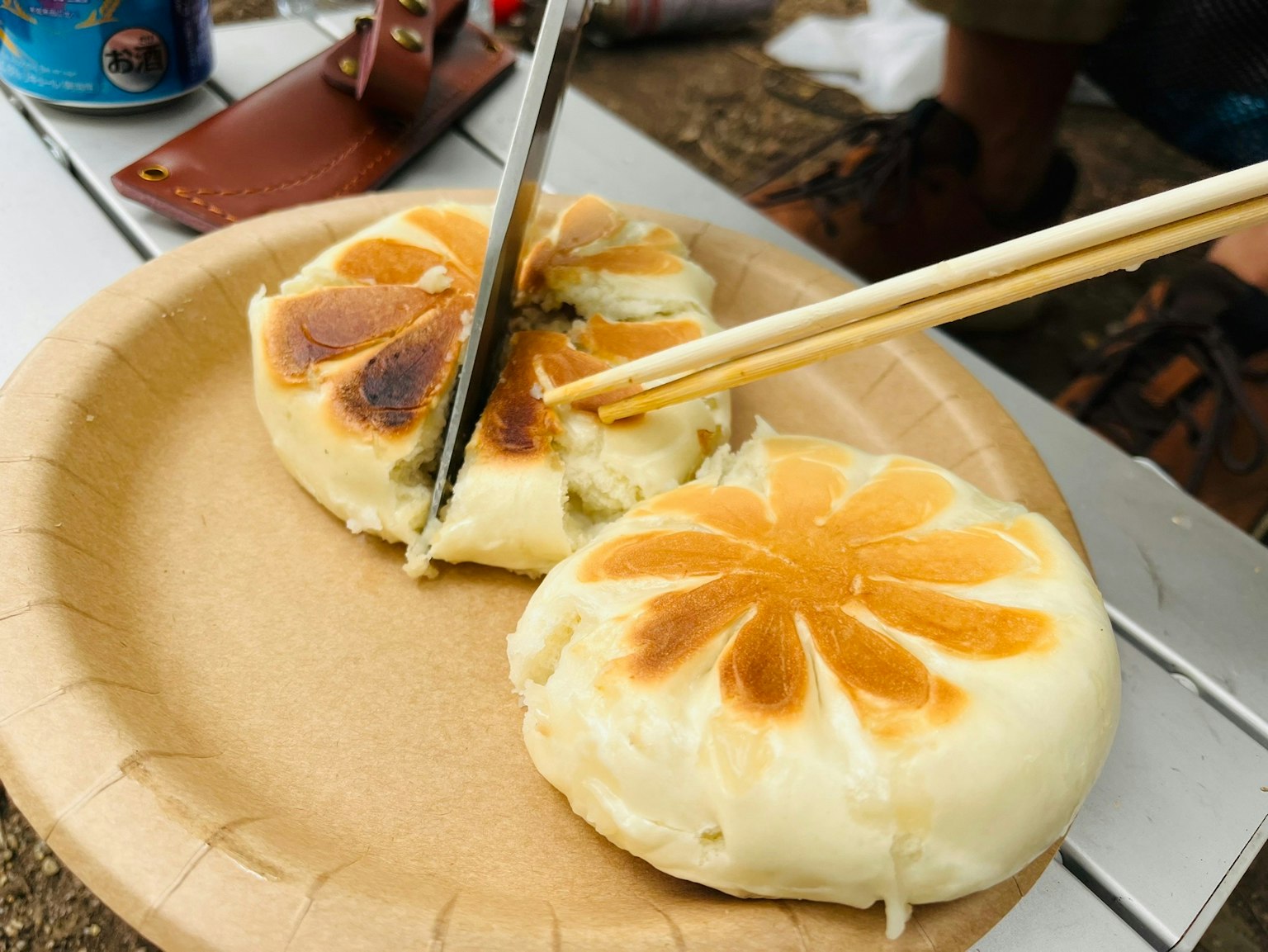 Cutting a steamed bun with floral pattern on a paper plate