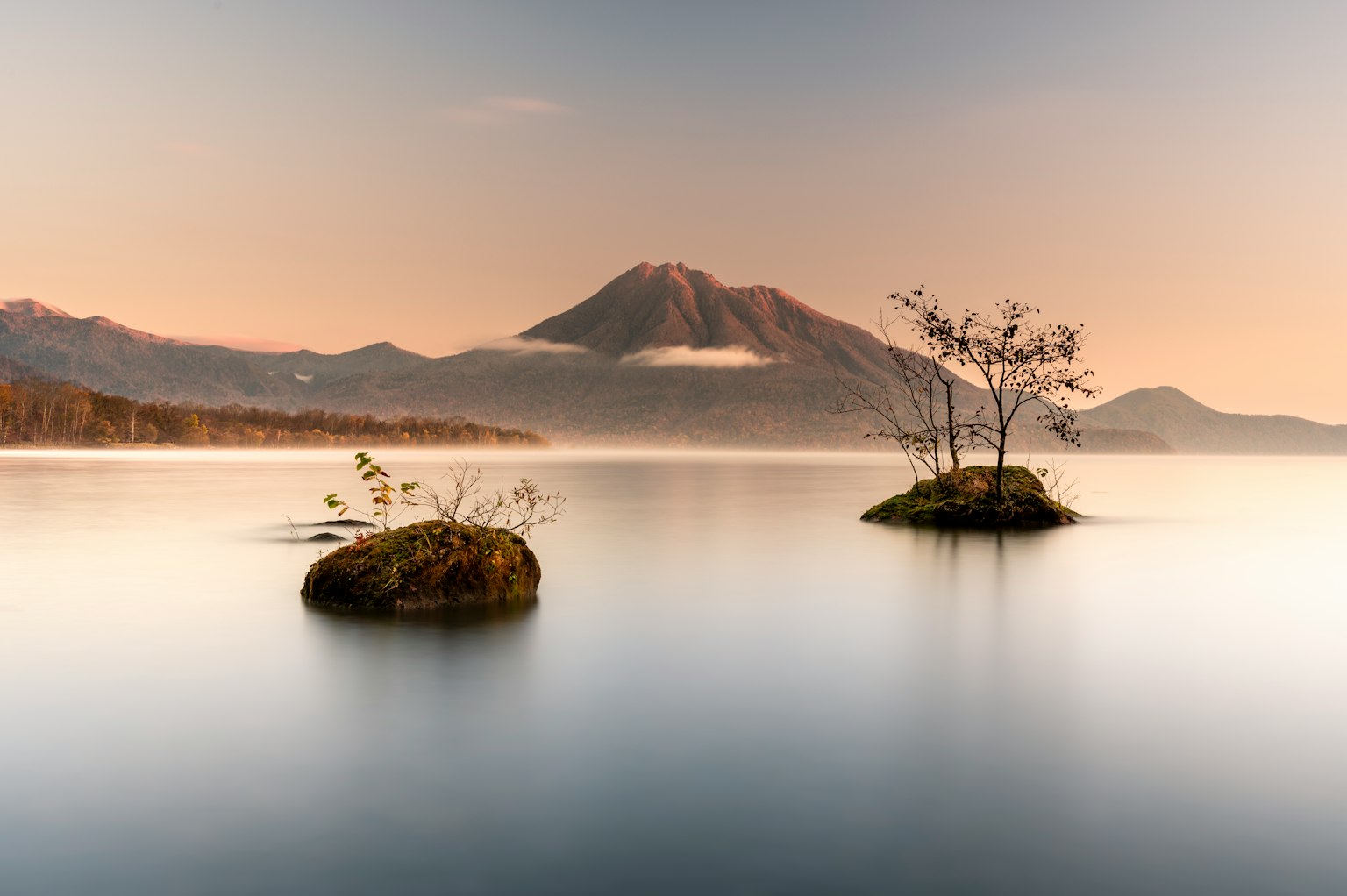 Lac serein avec de petites îles et des montagnes en arrière-plan