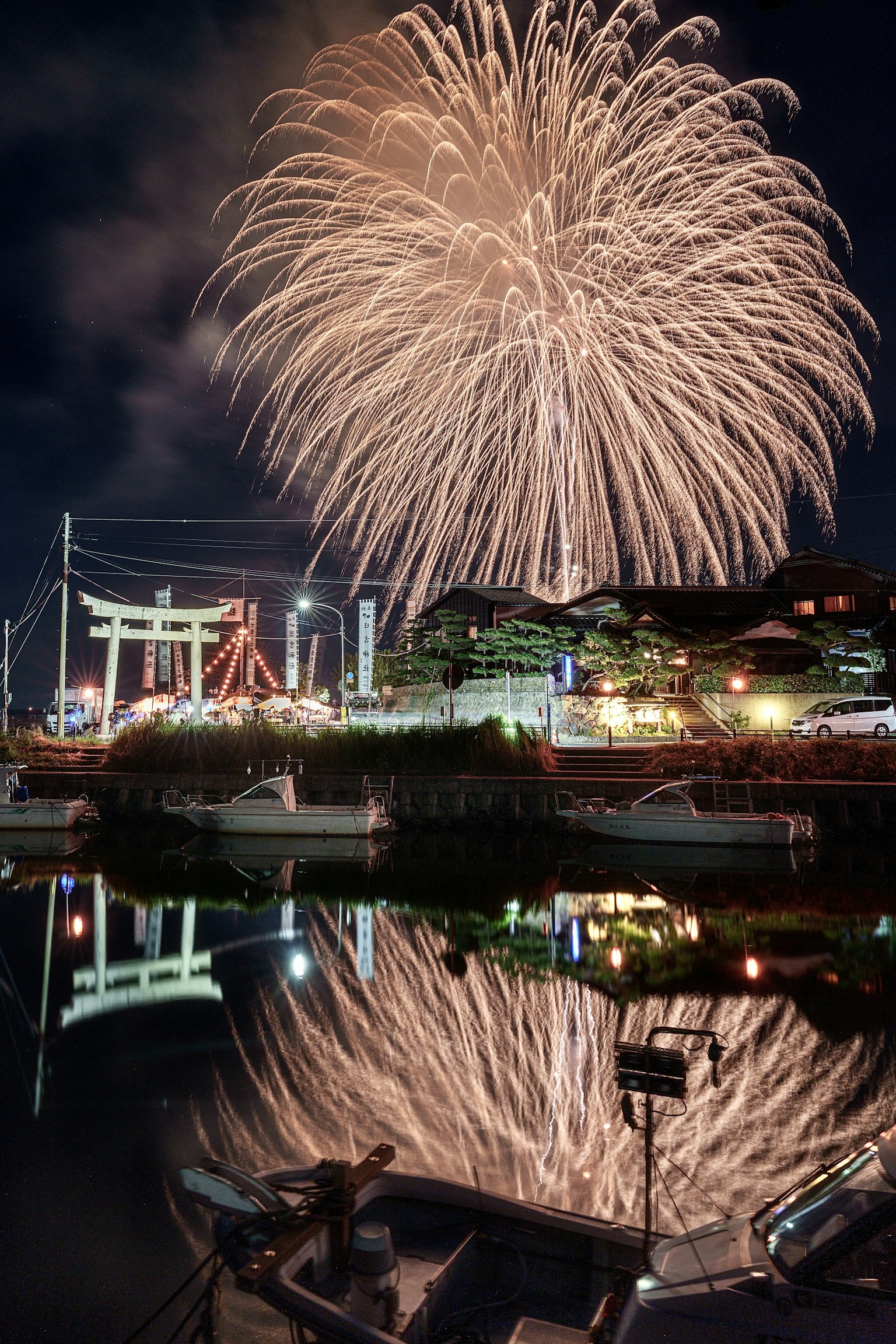 Fireworks illuminate the night sky with reflections on the water