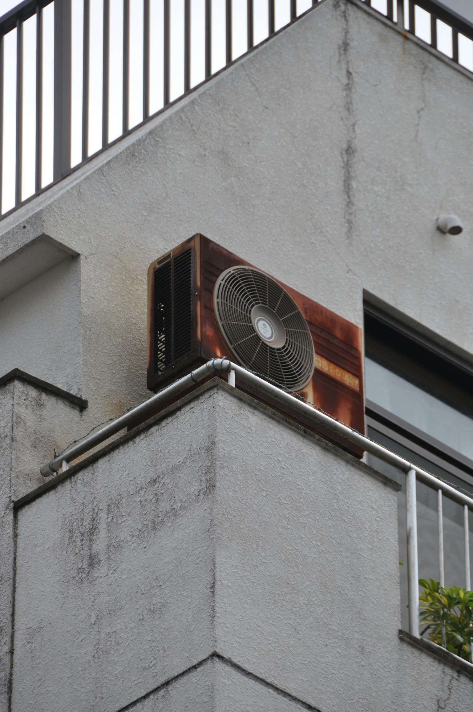 一台旧空调单位安装在建筑物的外墙上