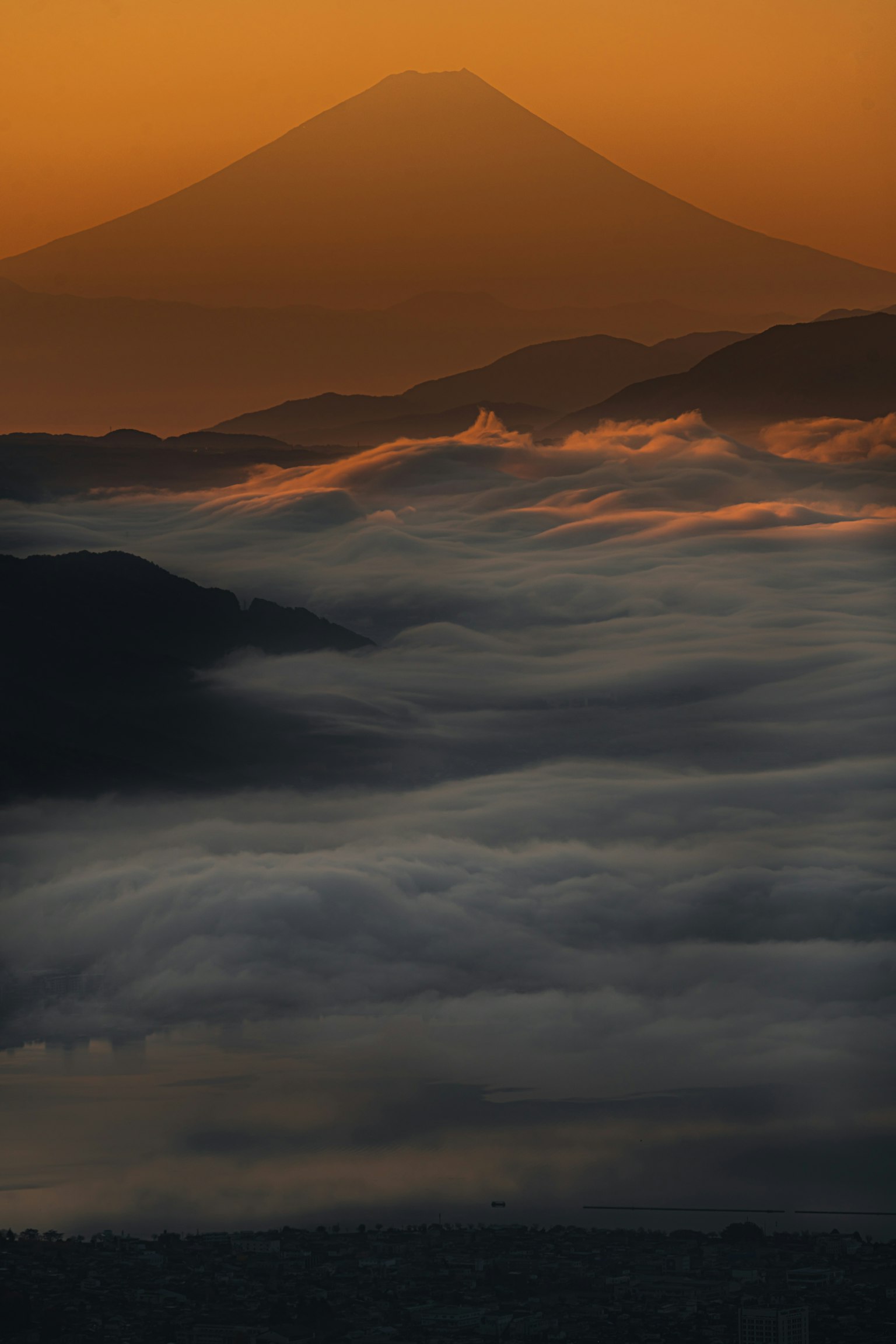 Pemandangan menakjubkan Gunung Fuji dikelilingi kabut pagi dan pegunungan