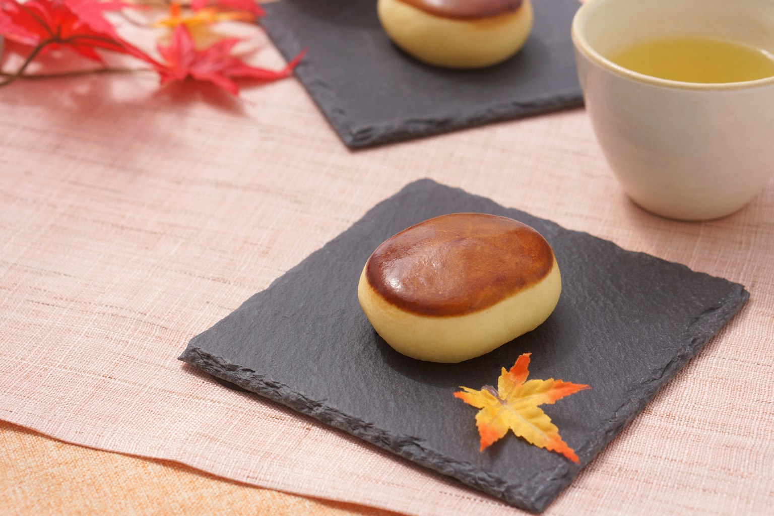 Eine ruhige Darstellung traditioneller japanischer Süßigkeiten und Tee mit Herbstblättern