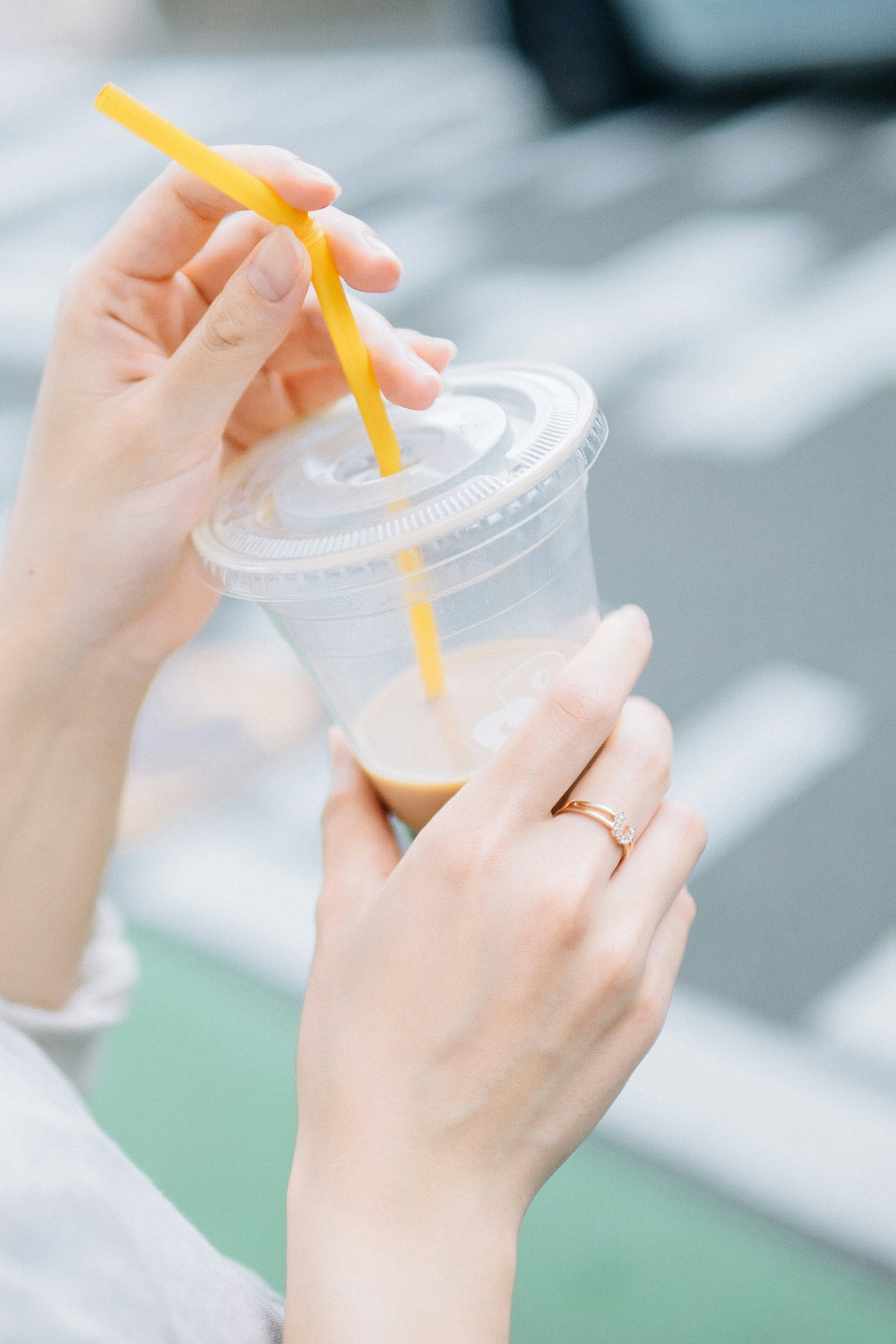 mains tenant une boisson en gobelet avec paille