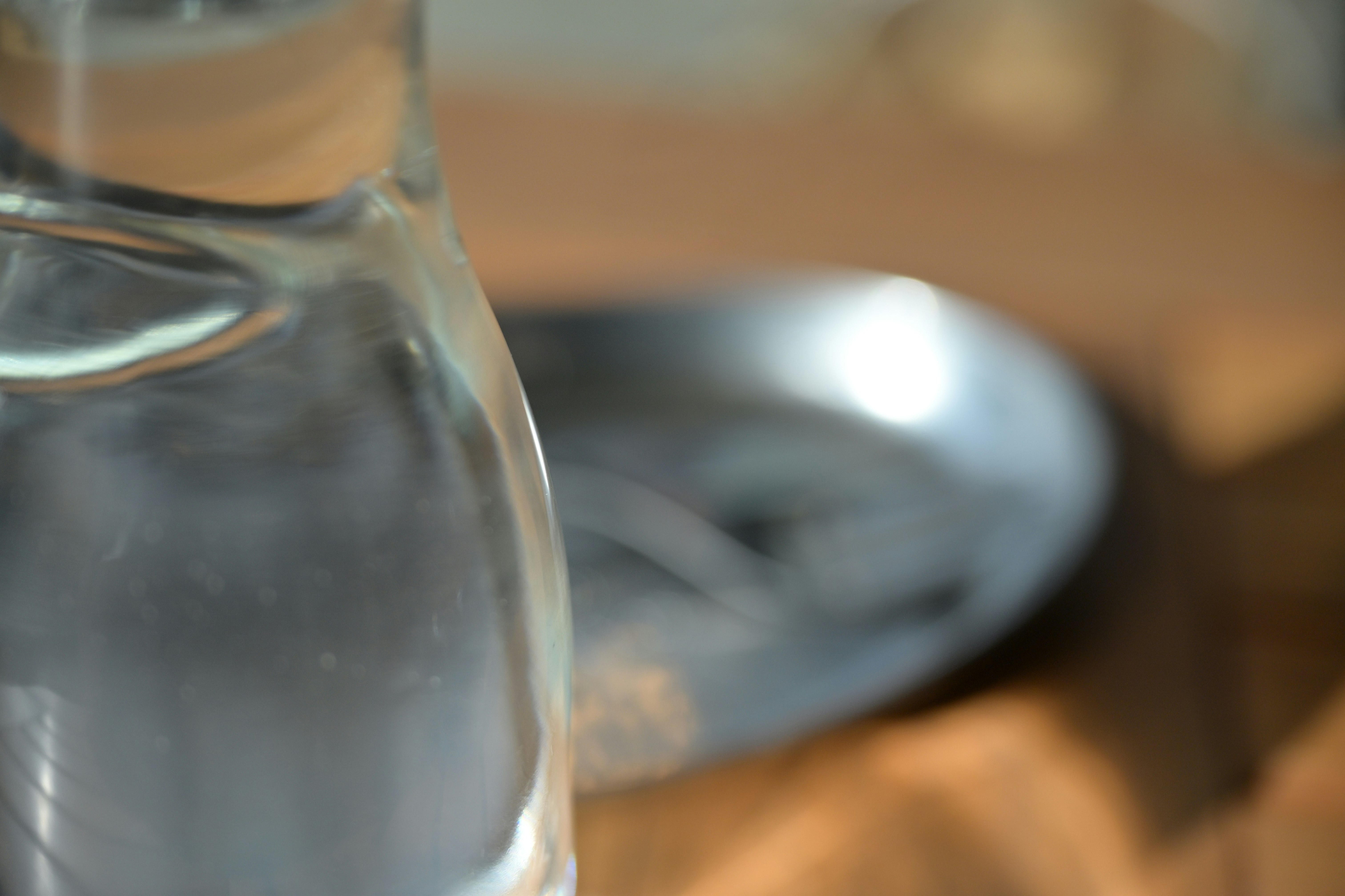 botol kaca berisi cairan bening dengan latar meja buram