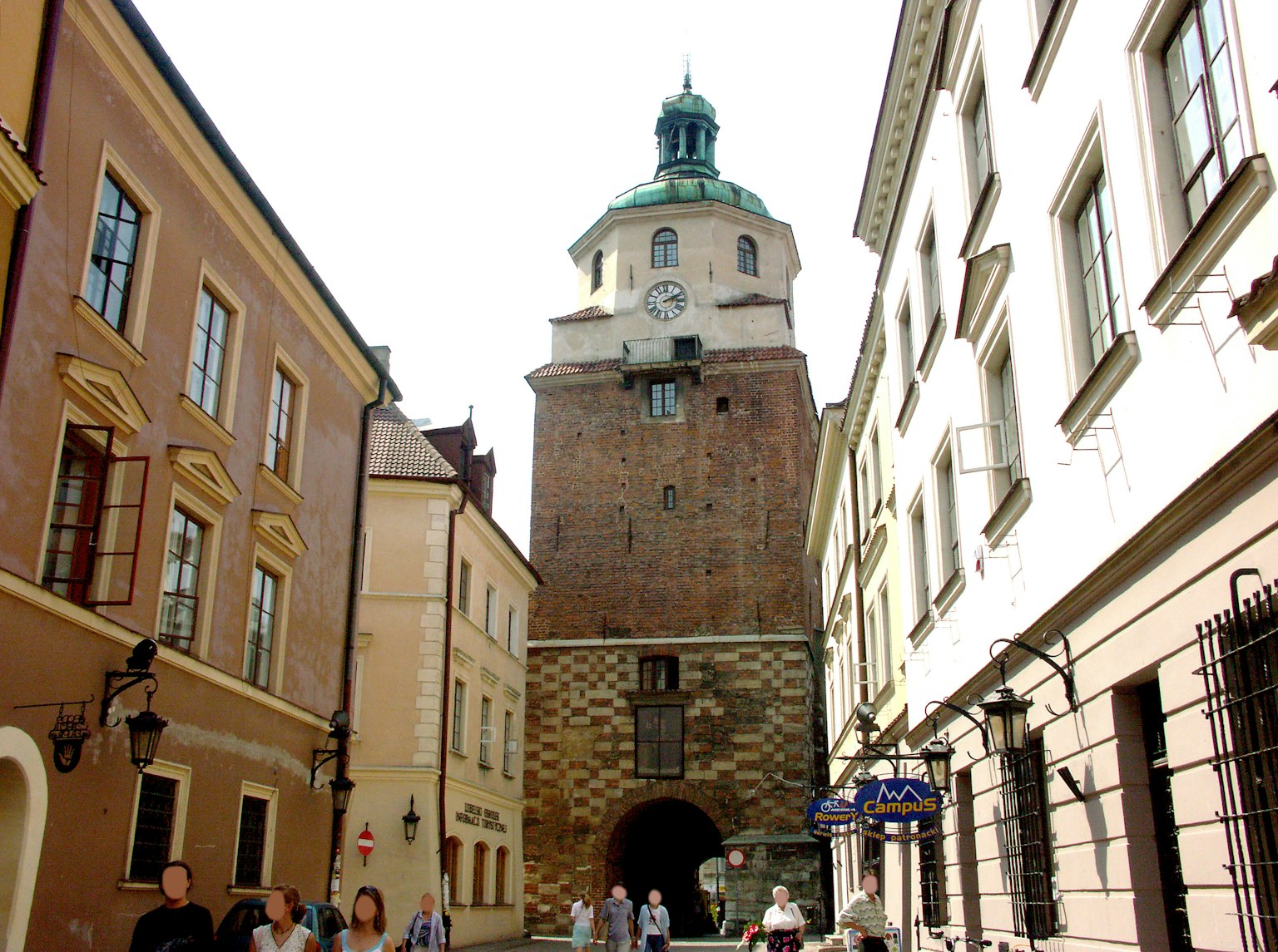 Historic tower in Krakow with surrounding buildings and people