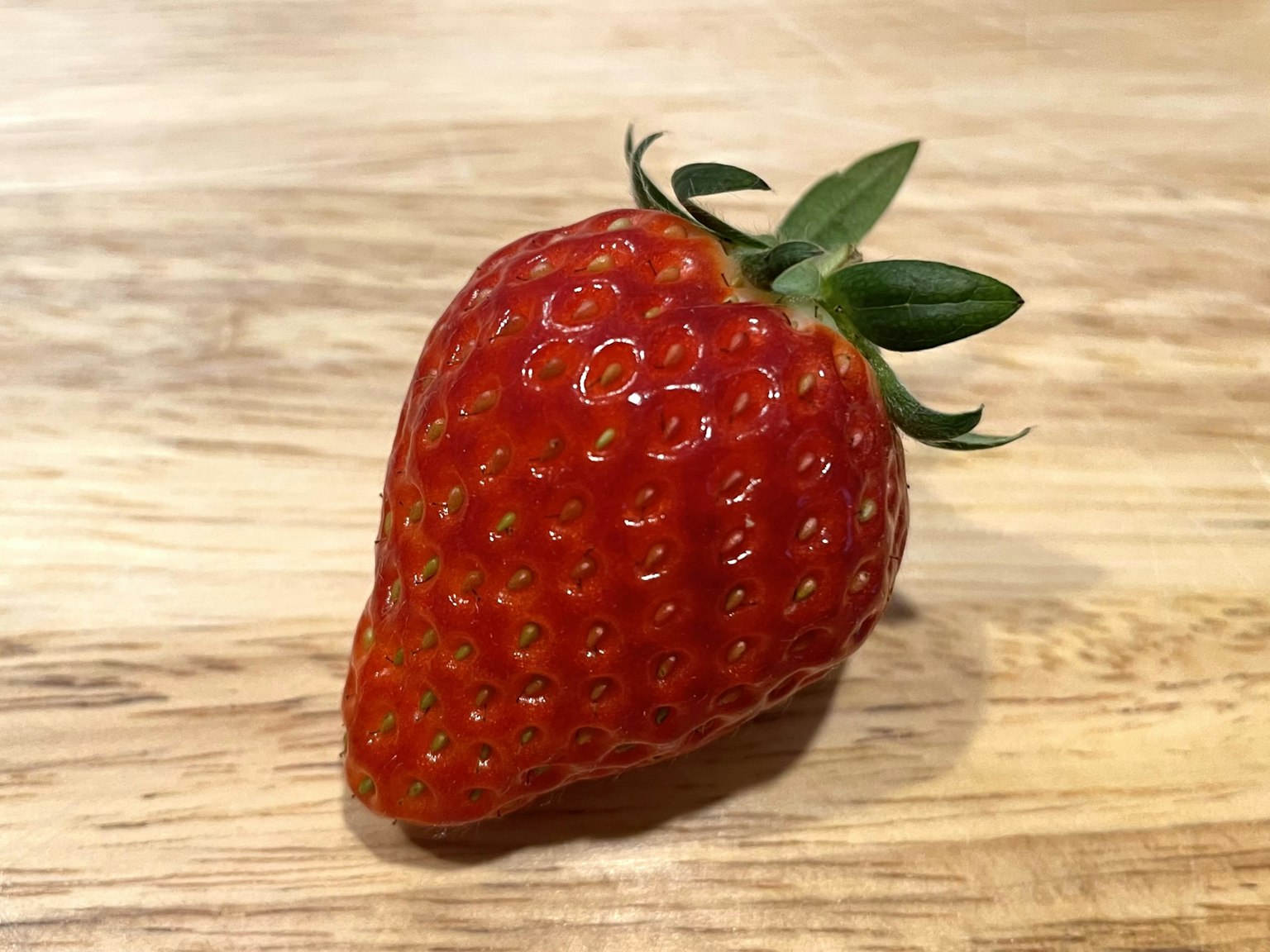 สตรอเบอร์รี่สีแดงสุกอยู่บนโต๊ะไม้