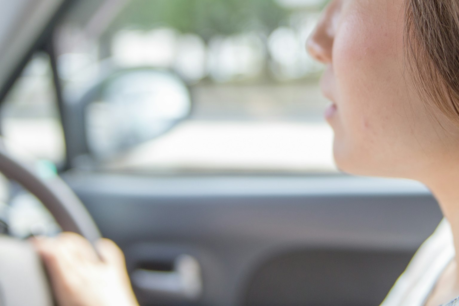Image of a woman driving seen from the side