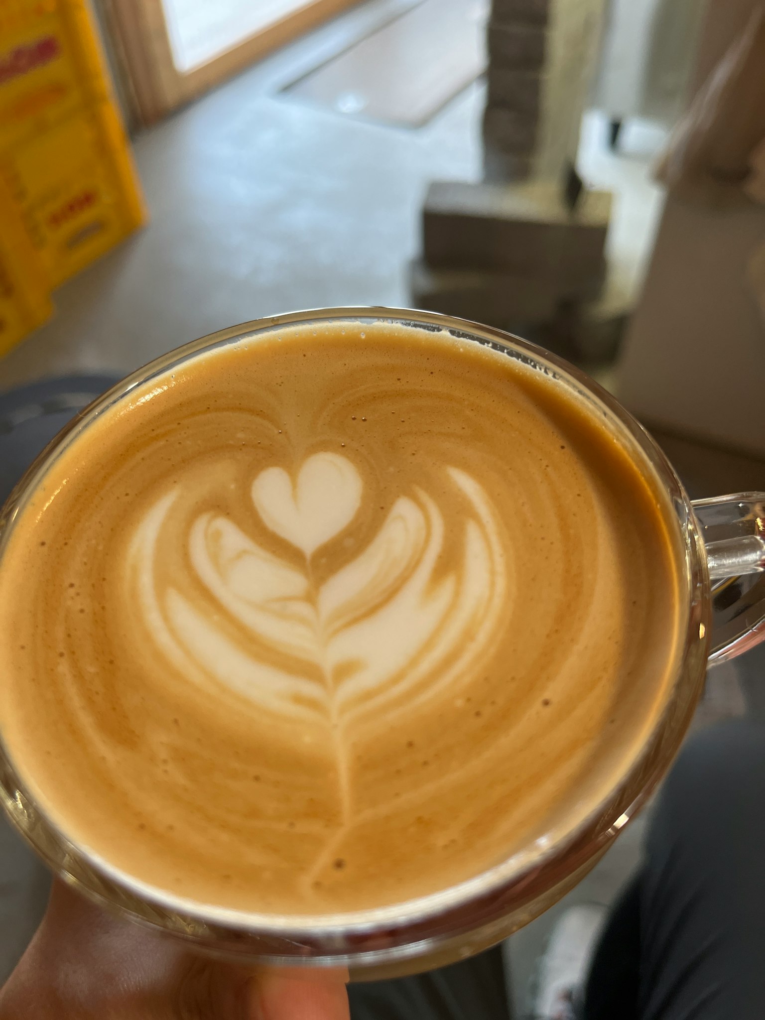 Cup of creamy latte art featuring a heart design