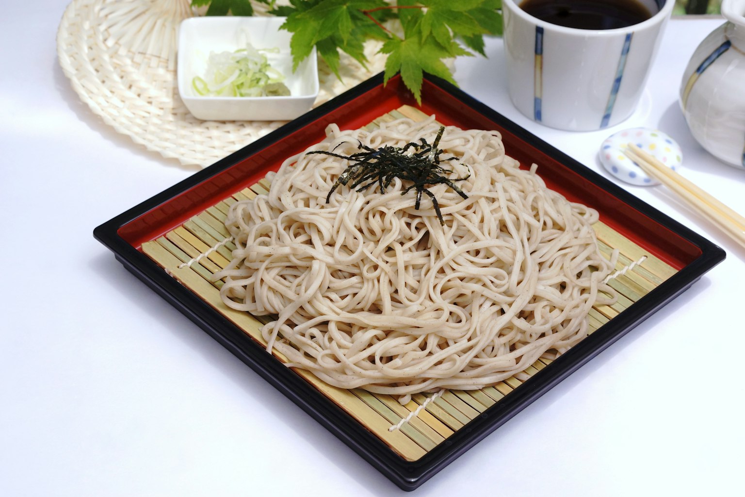 Soba auf einem schwarzen Teller mit einer traditionellen kleinen Schüssel serviert