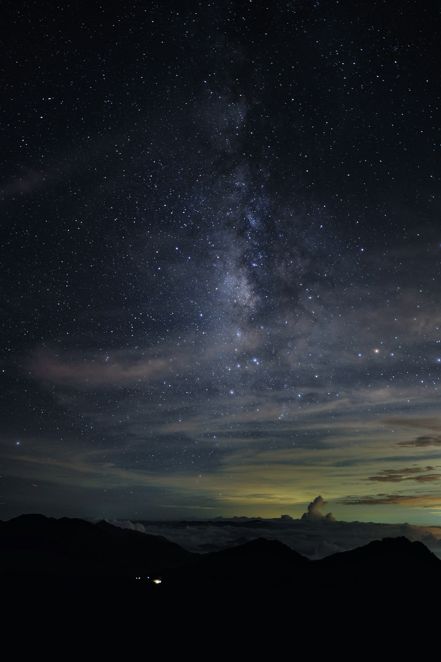 Via Lattea visibile in un cielo stellato con silhouette di montagne