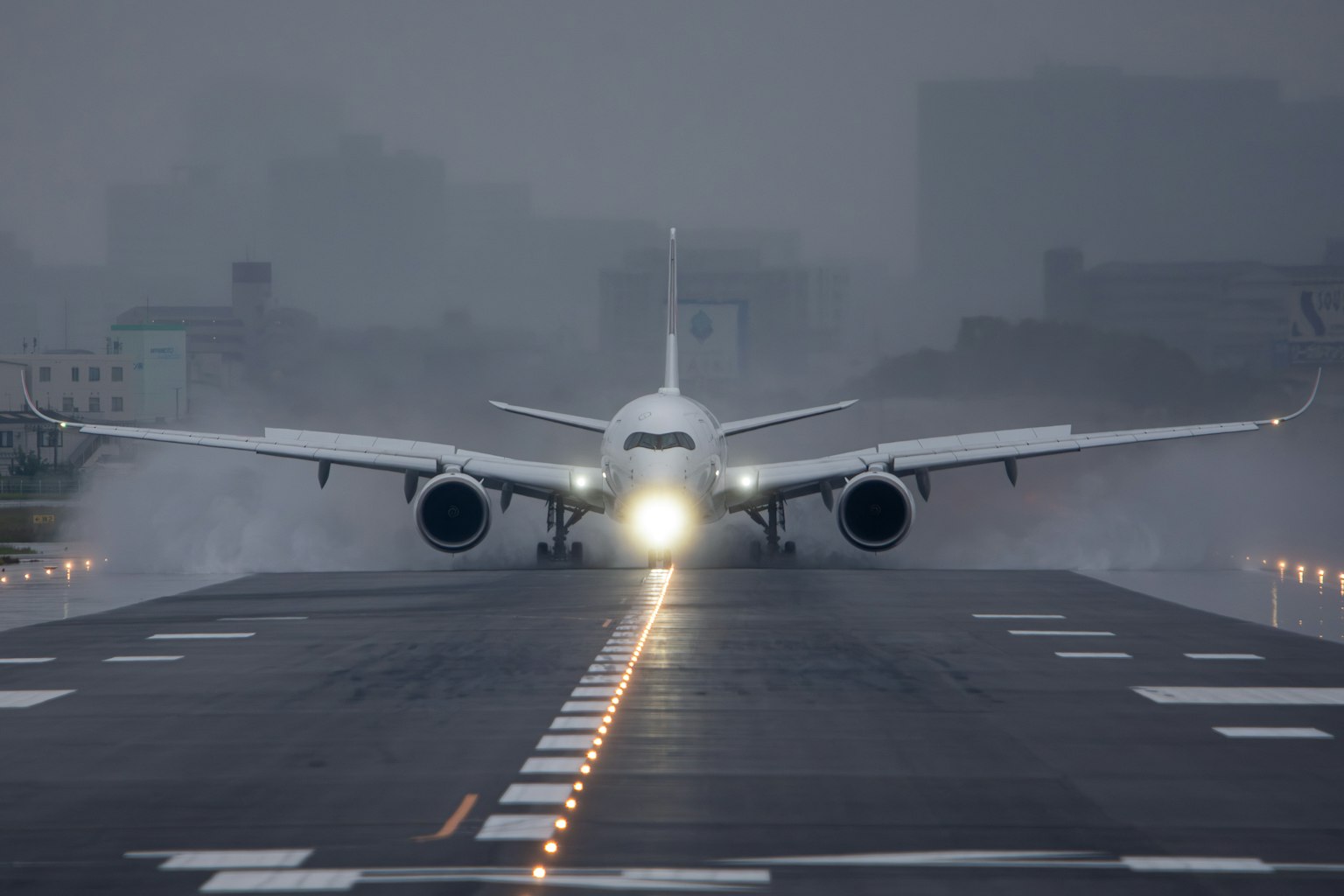 Avion atterrissant sur une piste dans un temps brumeux