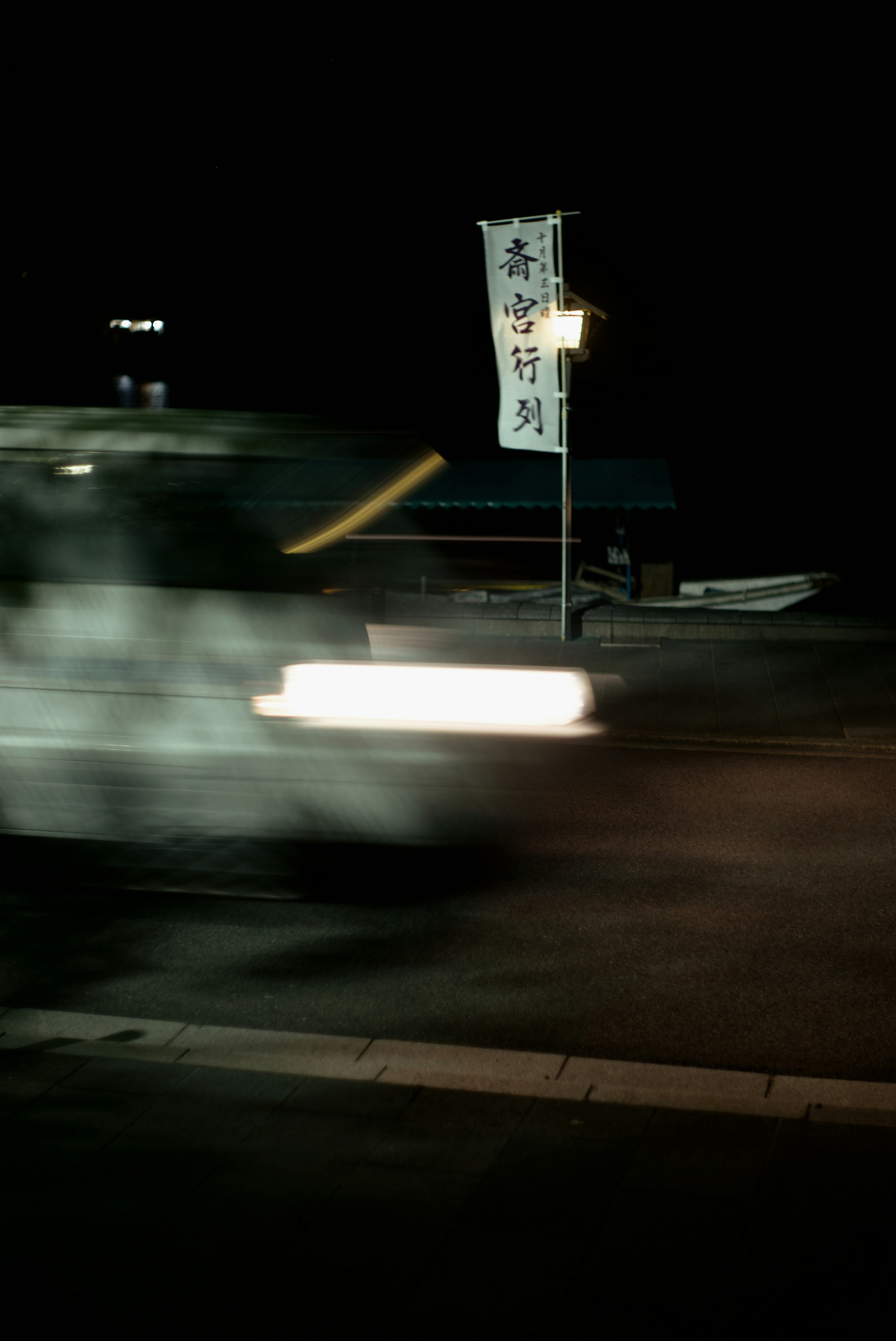 Night street in Arashiyama with a sign reading “Saigu Gyoretsu”