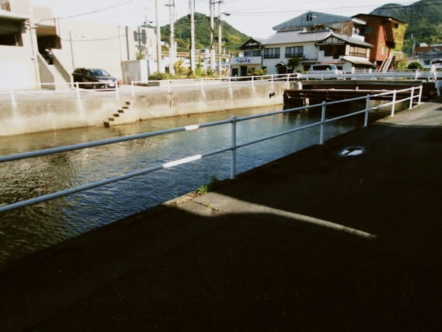 川沿いの歩道と建物の風景 鉄柵と水面が見える