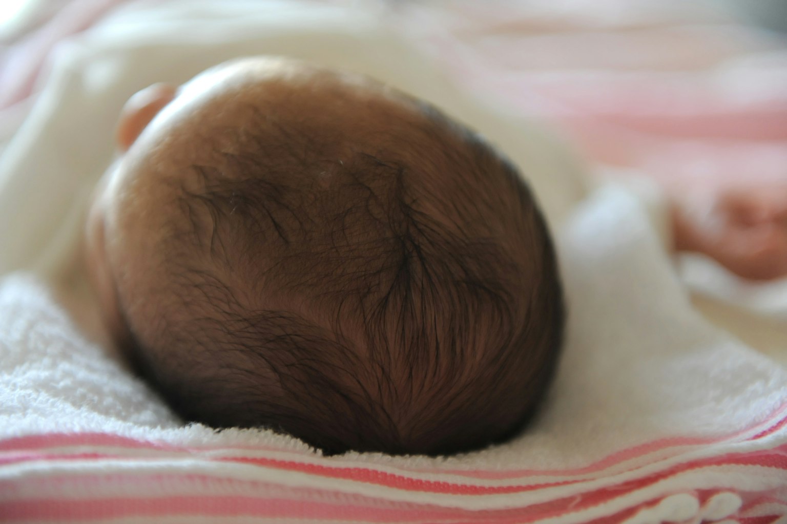 La testa di un neonato poggiata su un asciugamano morbido