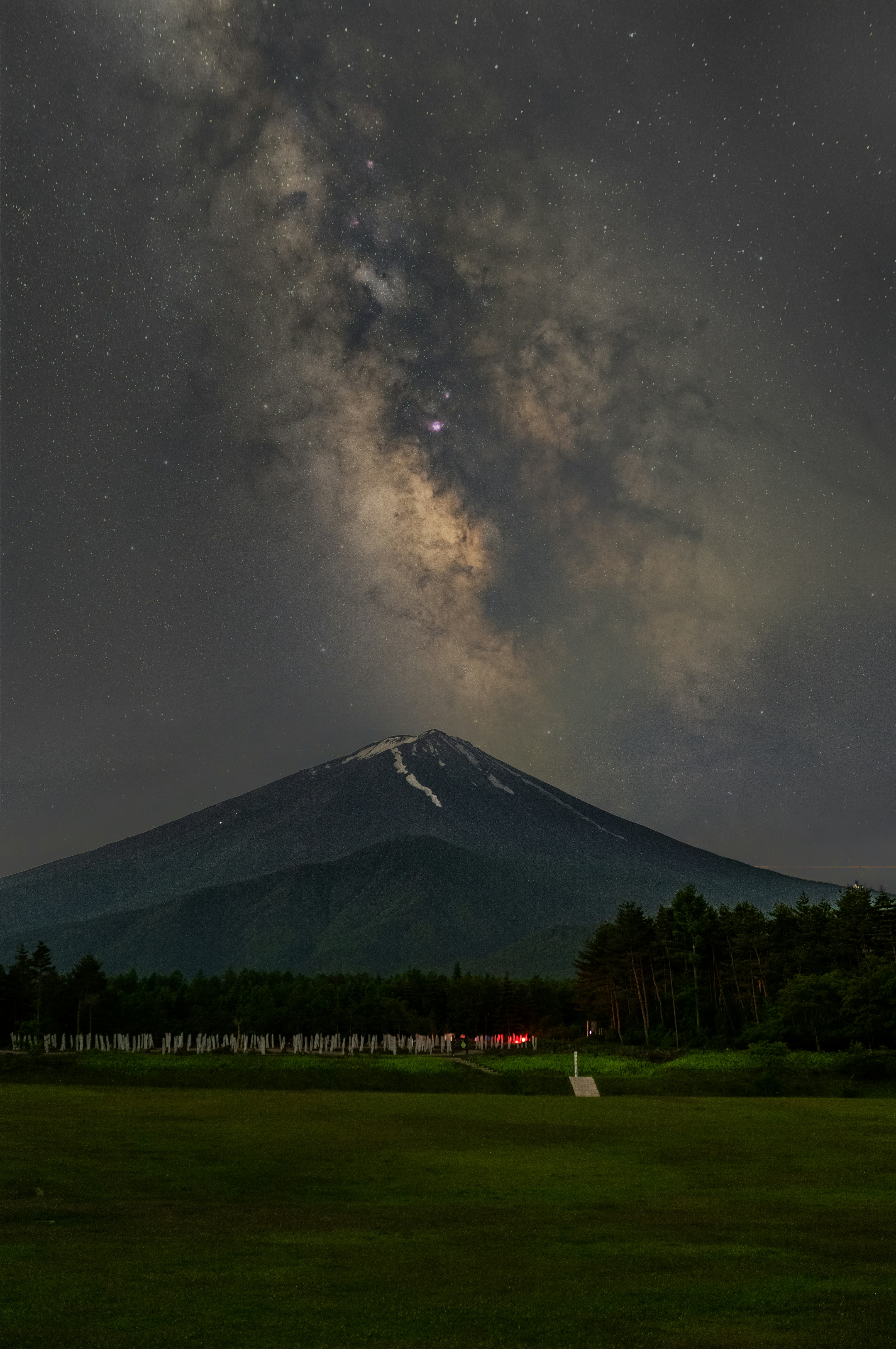 夜空に広がる天の川とシルエットの山並み