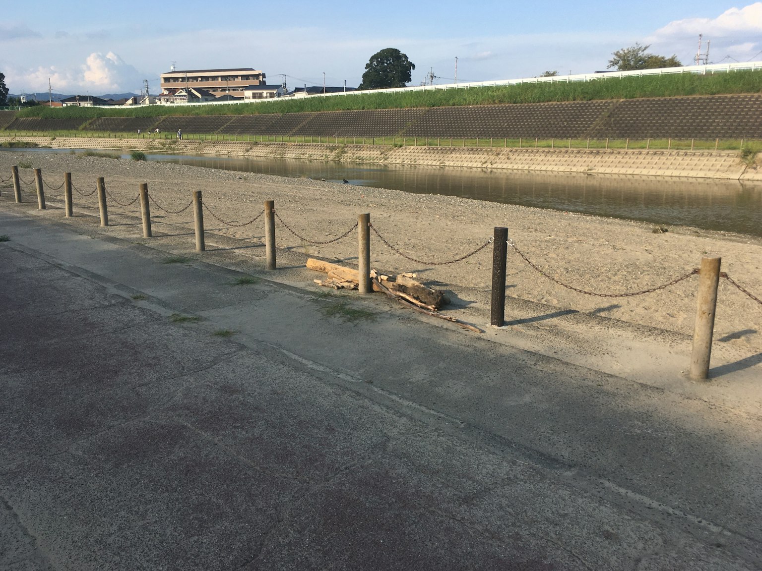 河岸旁的木圍欄與乾燥的土壤和遠處的建築