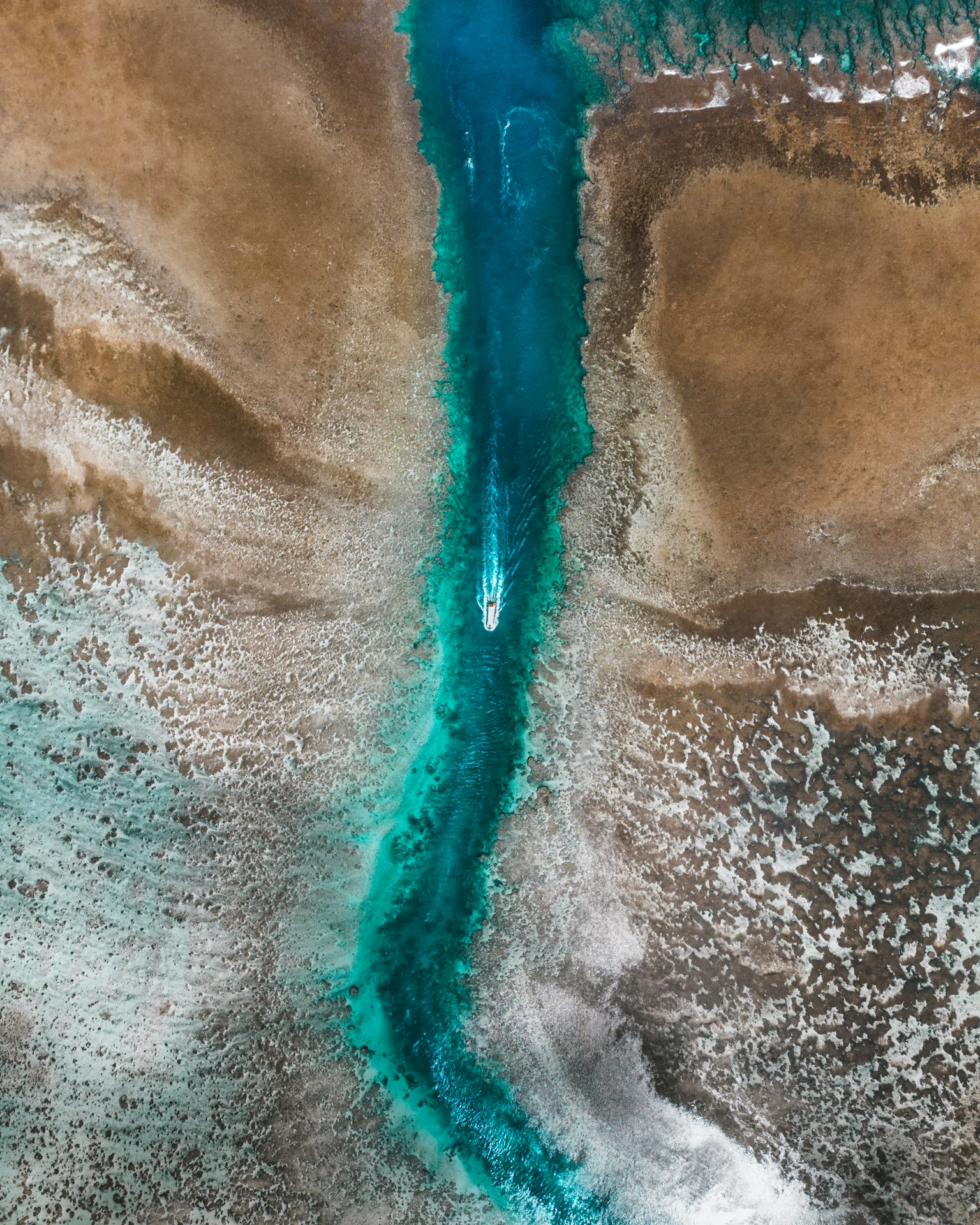 Vista aérea de un vibrante canal azul en contraste con la tierra seca
