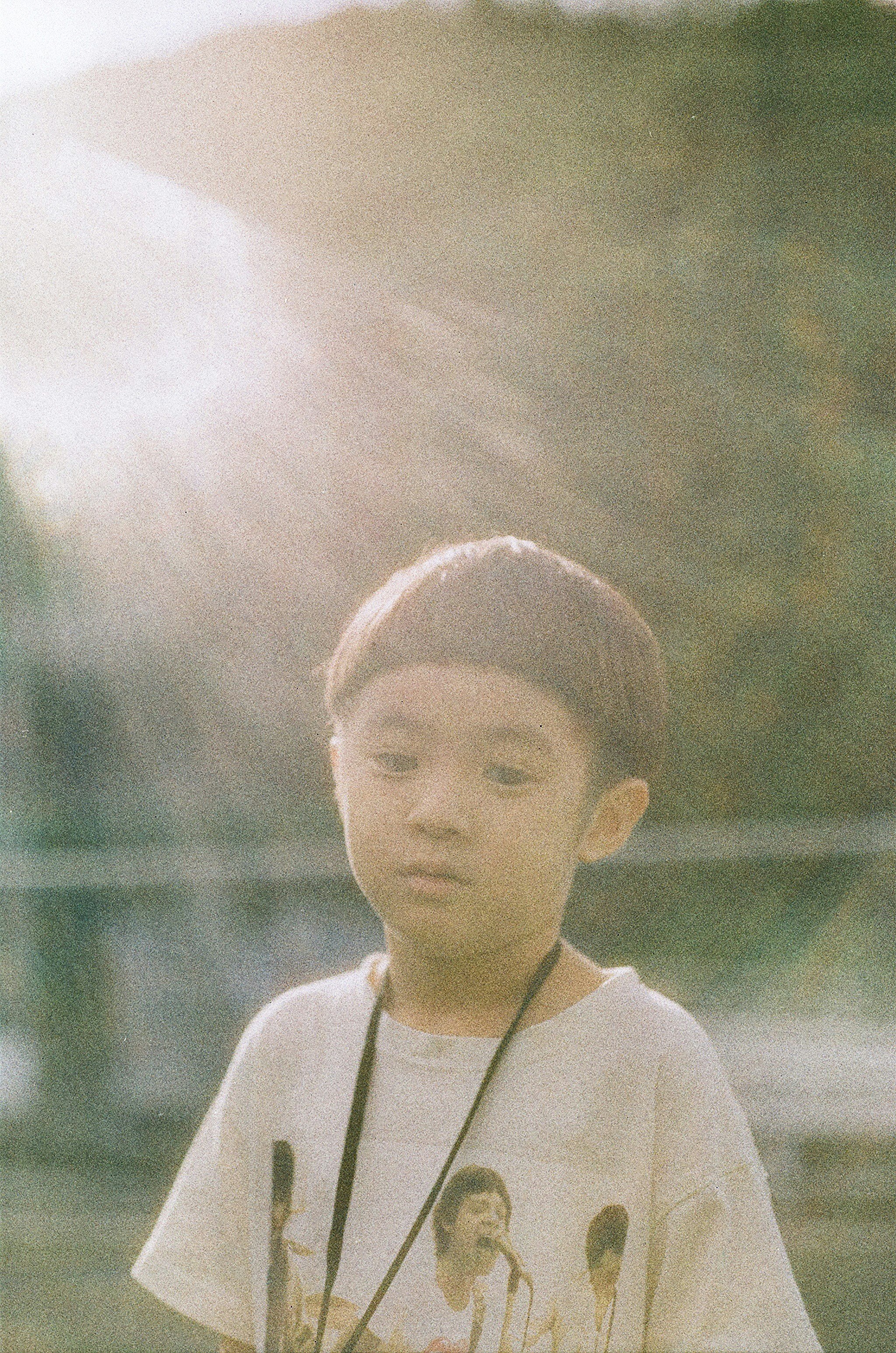 公園の背景で立つ子どもの後ろ姿