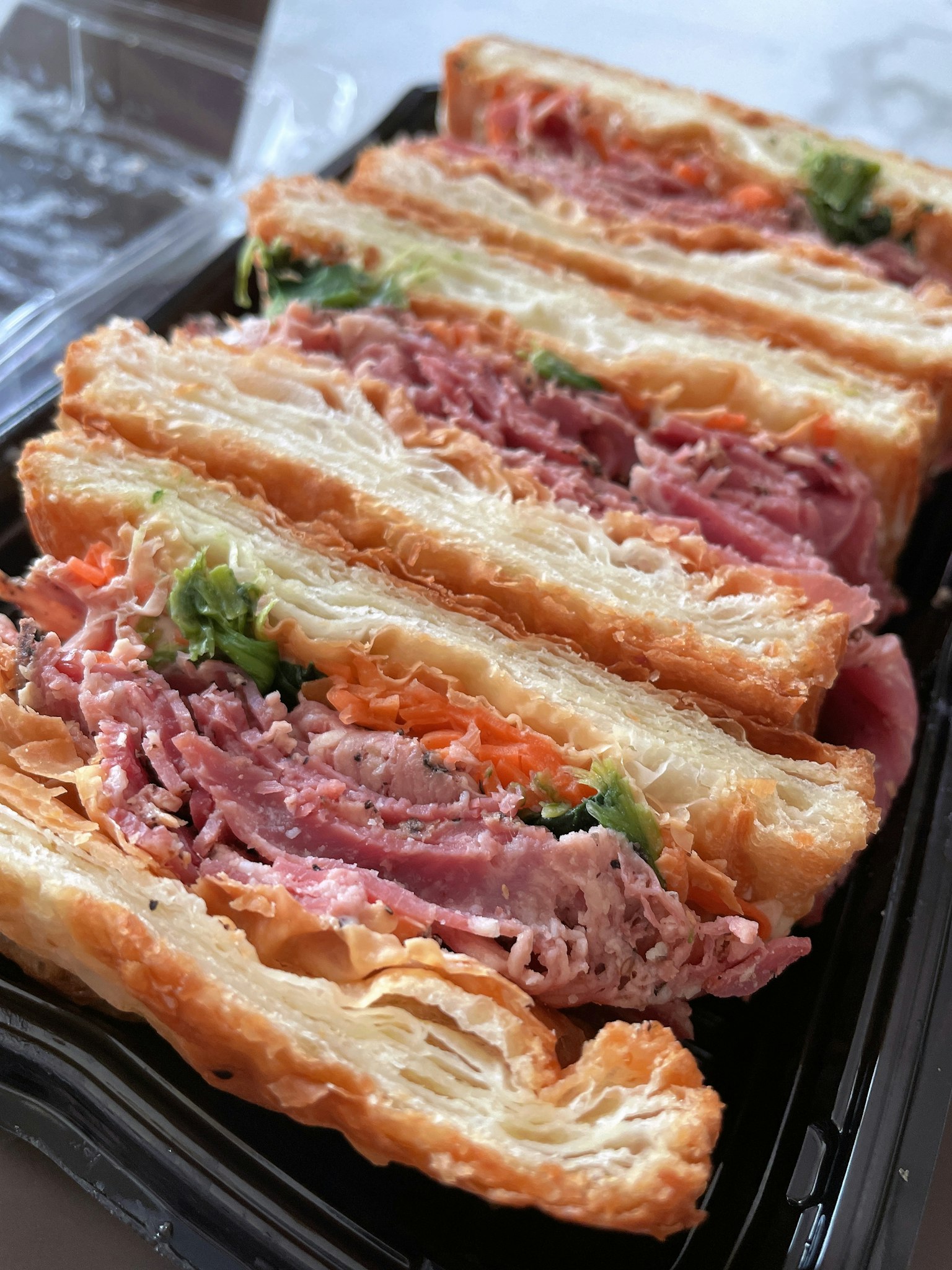 Cận cảnh một chiếc bánh sandwich ngon với các lớp thịt và rau