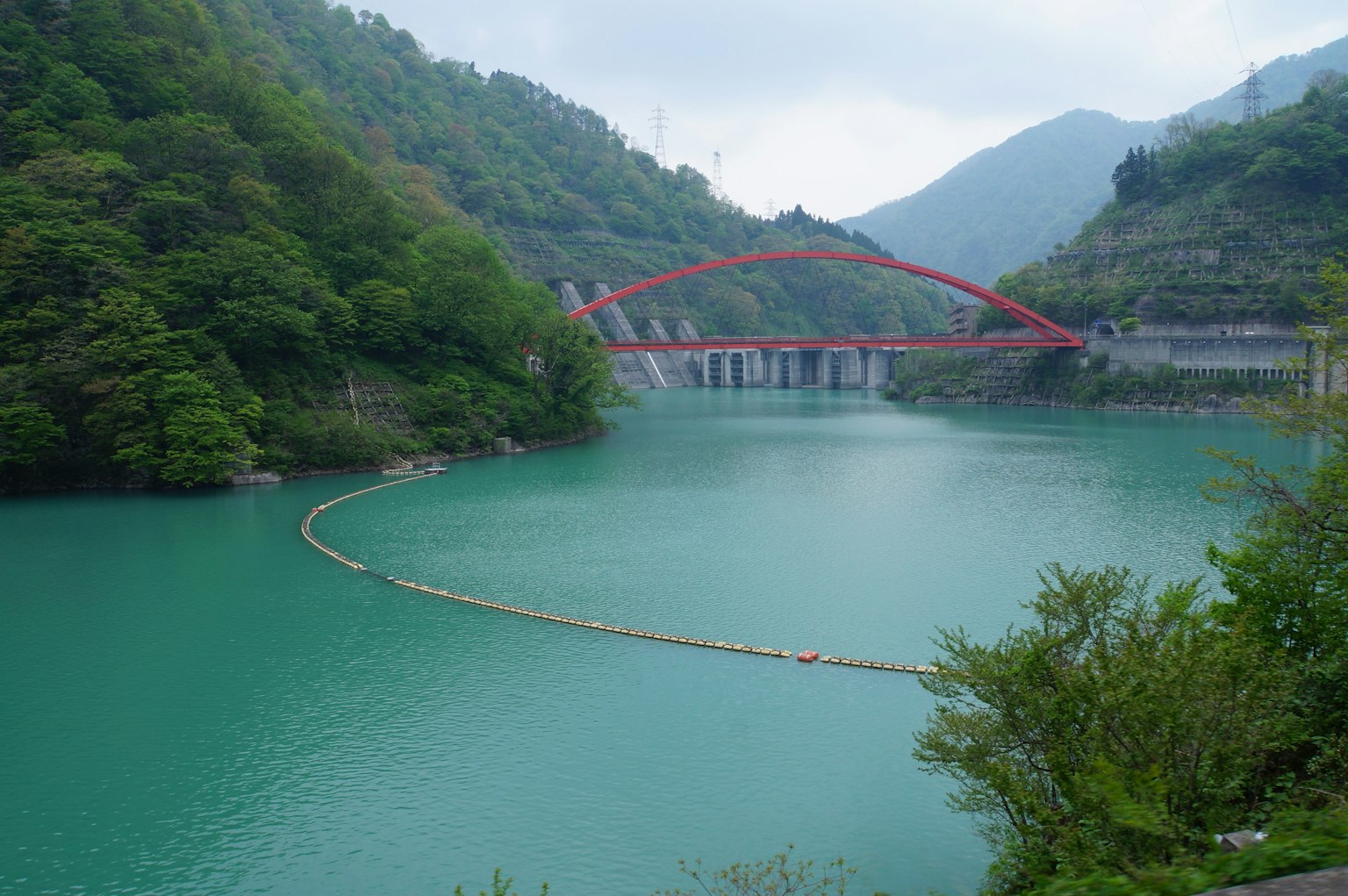 風景如畫的圖像，展示了一個綠松石湖和引人注目的紅色橋樑