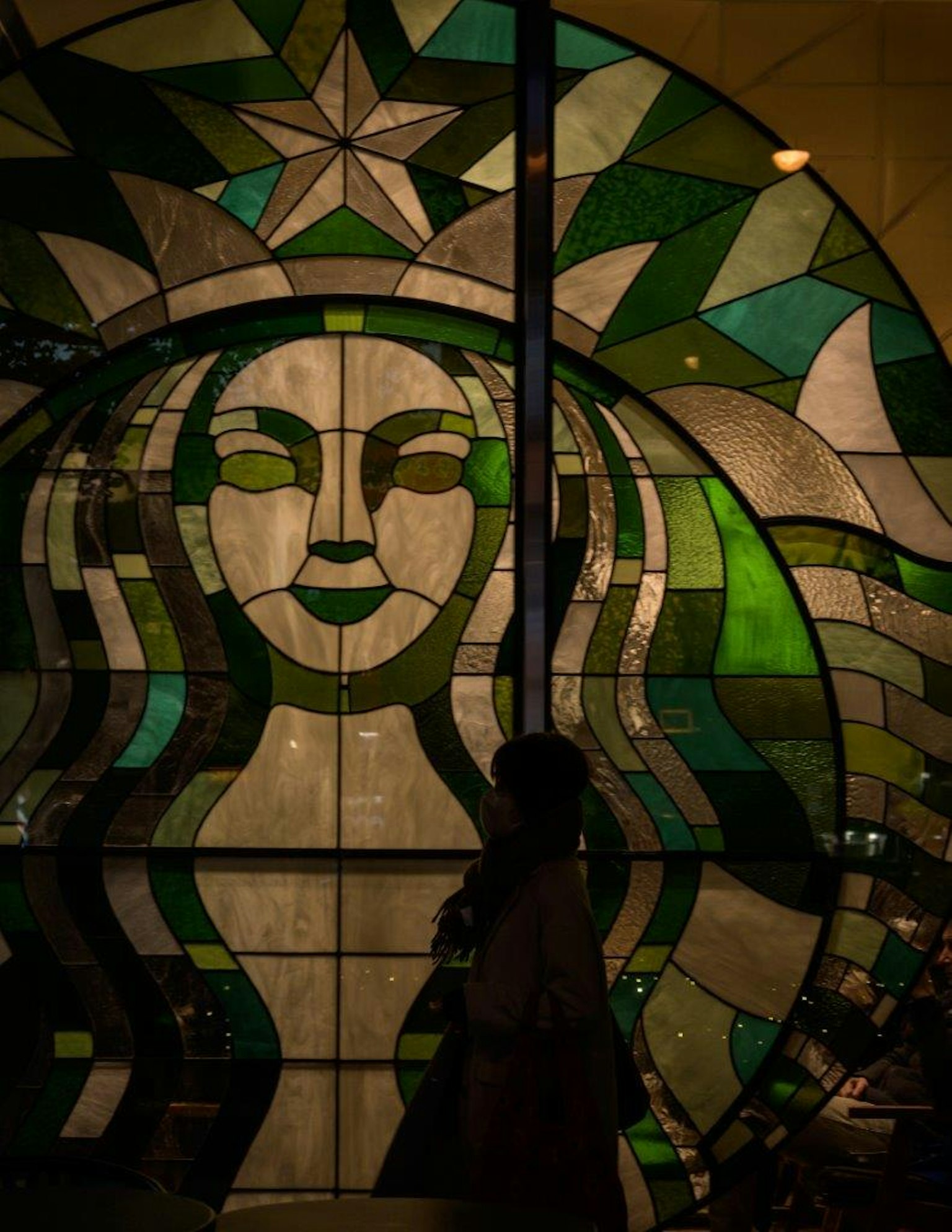 Colorful stained glass art featuring Starbucks logo and silhouette of a woman