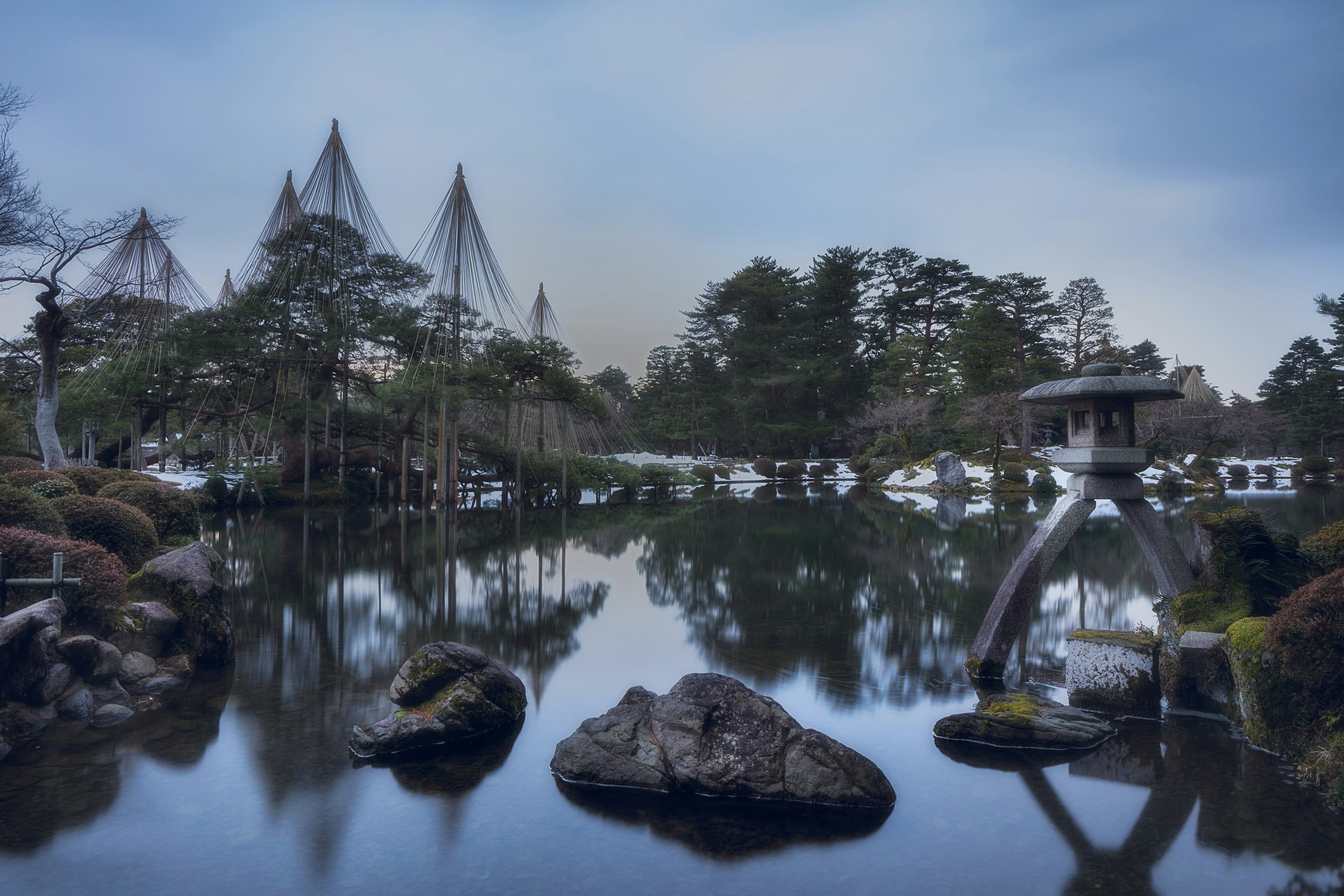 池に浮かぶ石と和風の庭園の景色