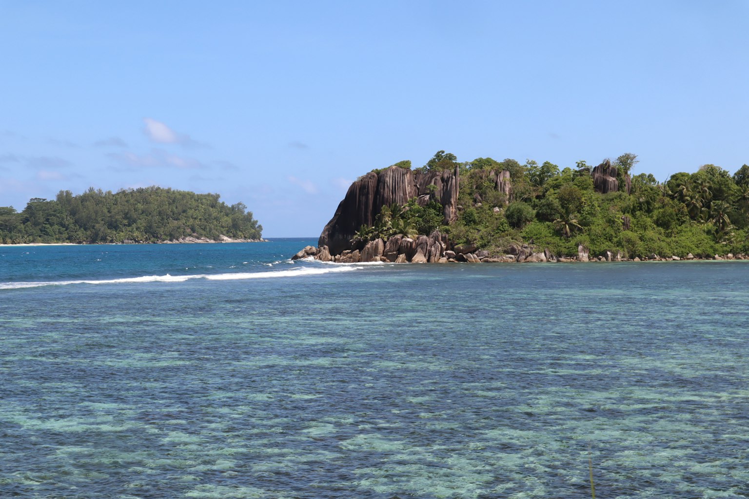 美丽的海景，有岩石和郁郁葱葱的岛屿，蓝天之下