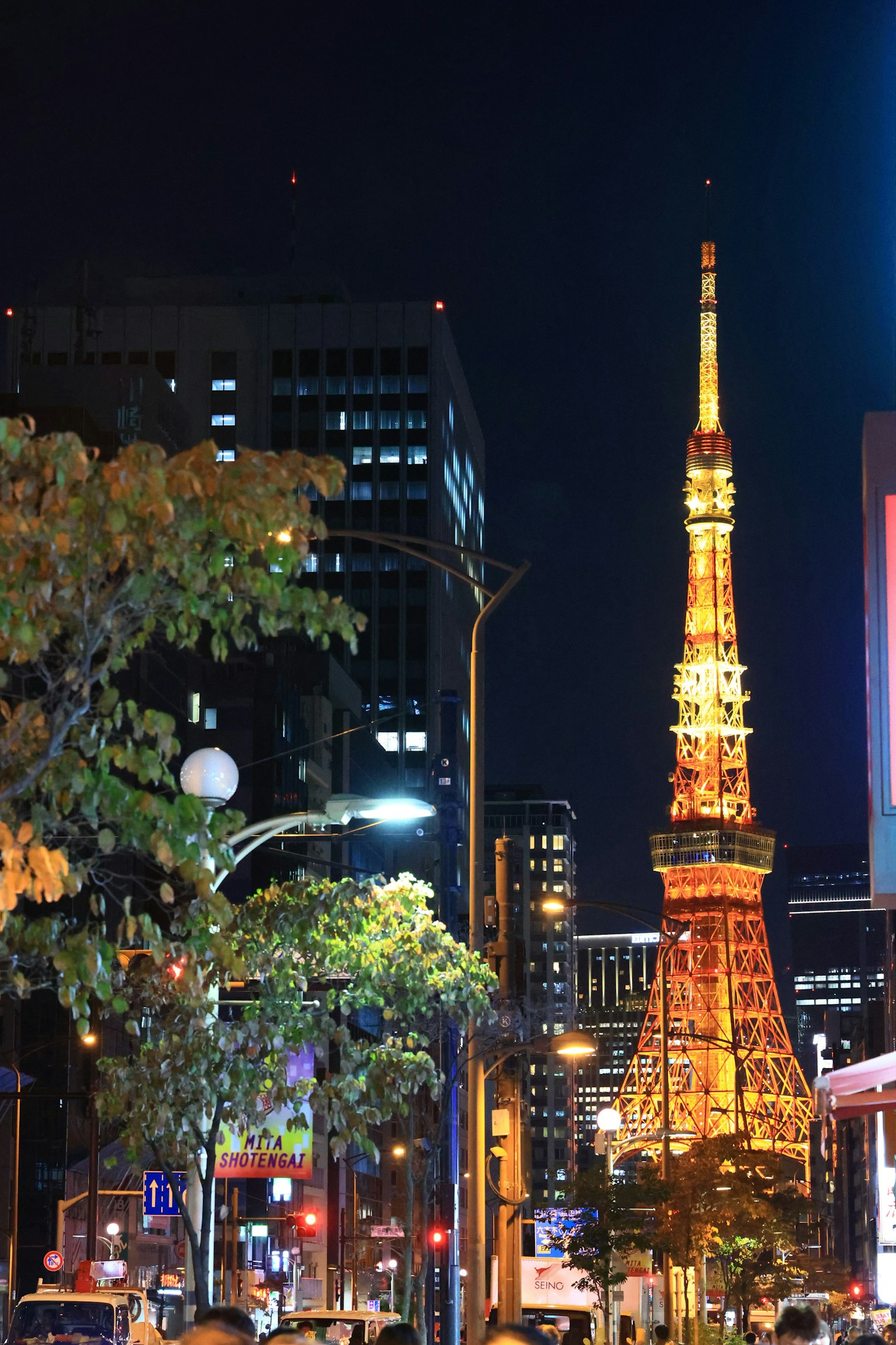 Torre di Tokyo illuminata di notte con edifici della città sullo sfondo