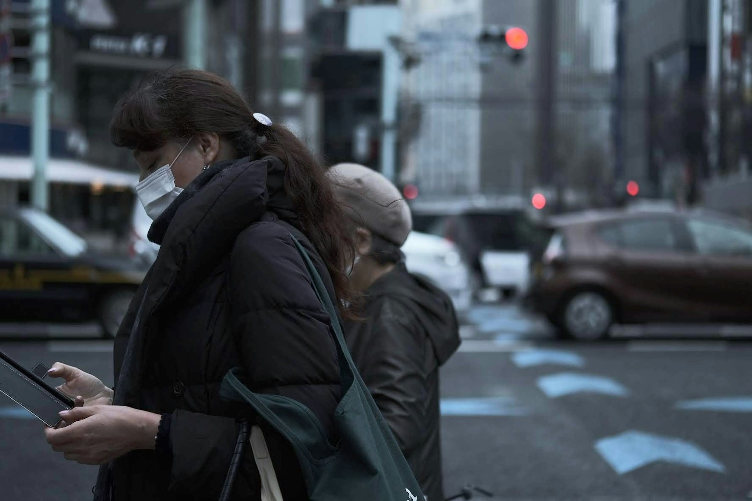 Deux femmes à un passage piéton urbain utilisant des smartphones