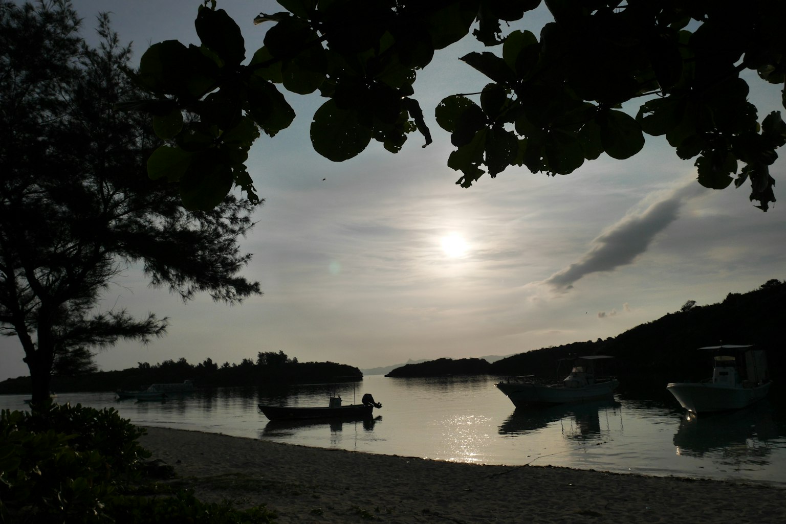Spiaggia tranquilla con barche e un tramonto sereno