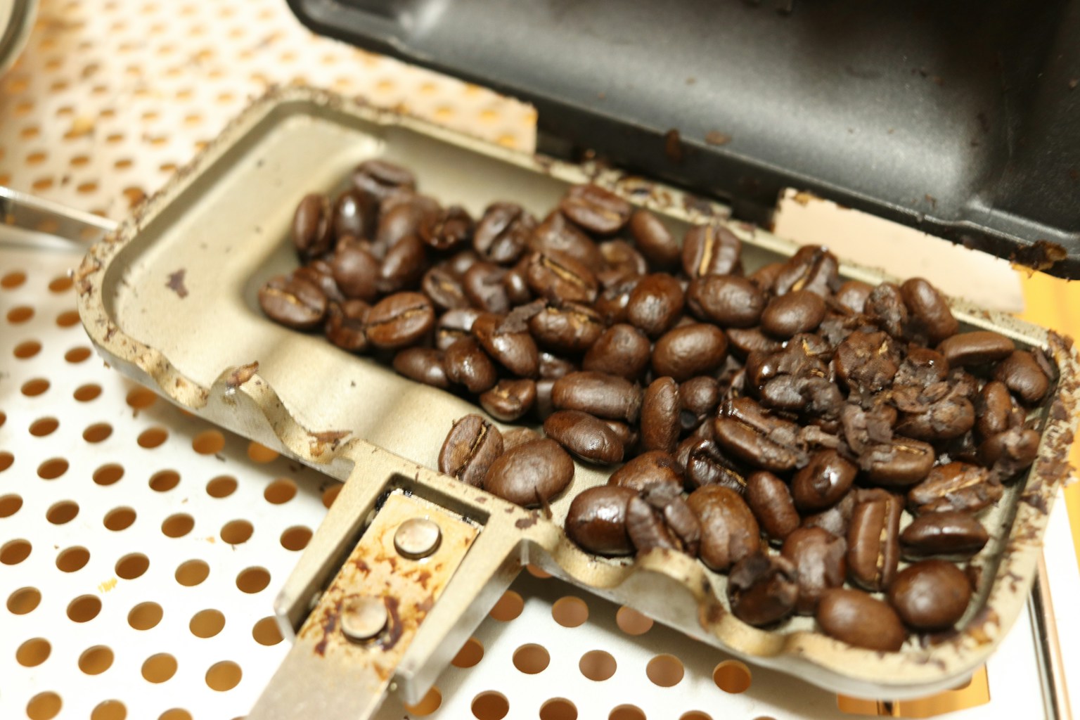 ถาดที่มีเมล็ดกาแฟคั่วในเครื่องบดกาแฟแบบวินเทจ