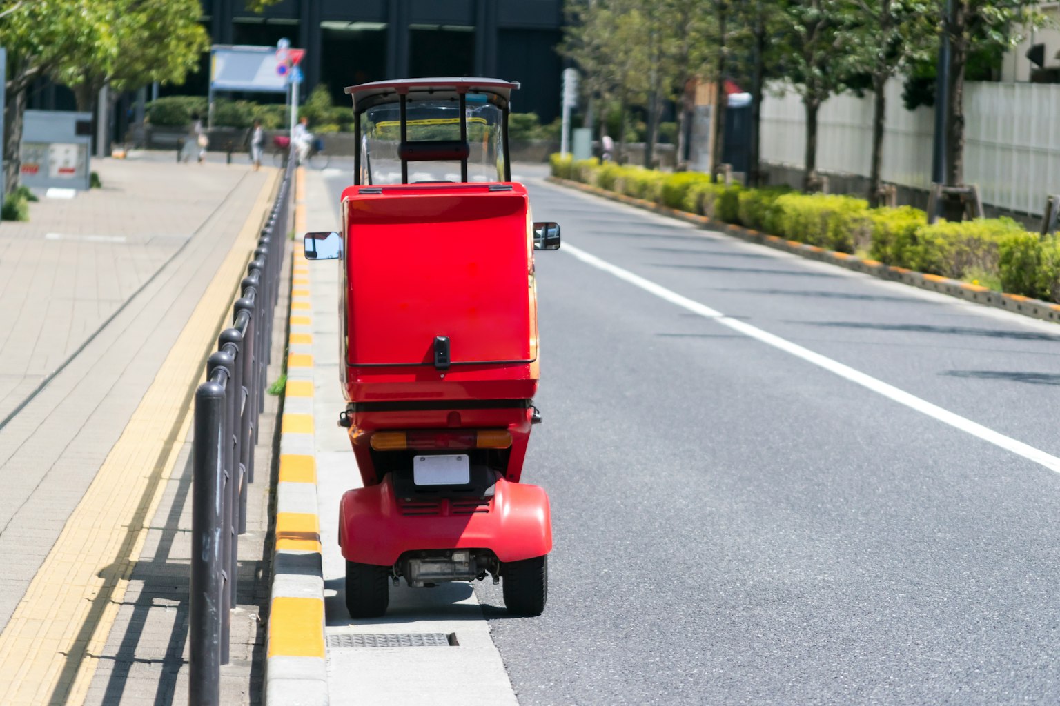 Un triciclo rosso parcheggiato sul lato della strada