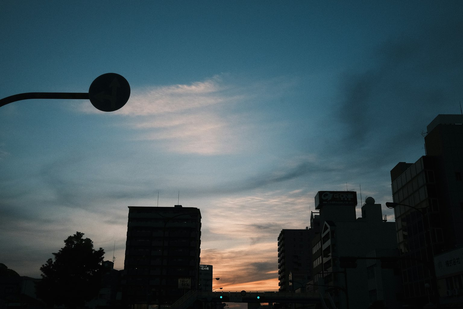 Silhouette de bâtiments contre un ciel crépusculaire avec un lampadaire