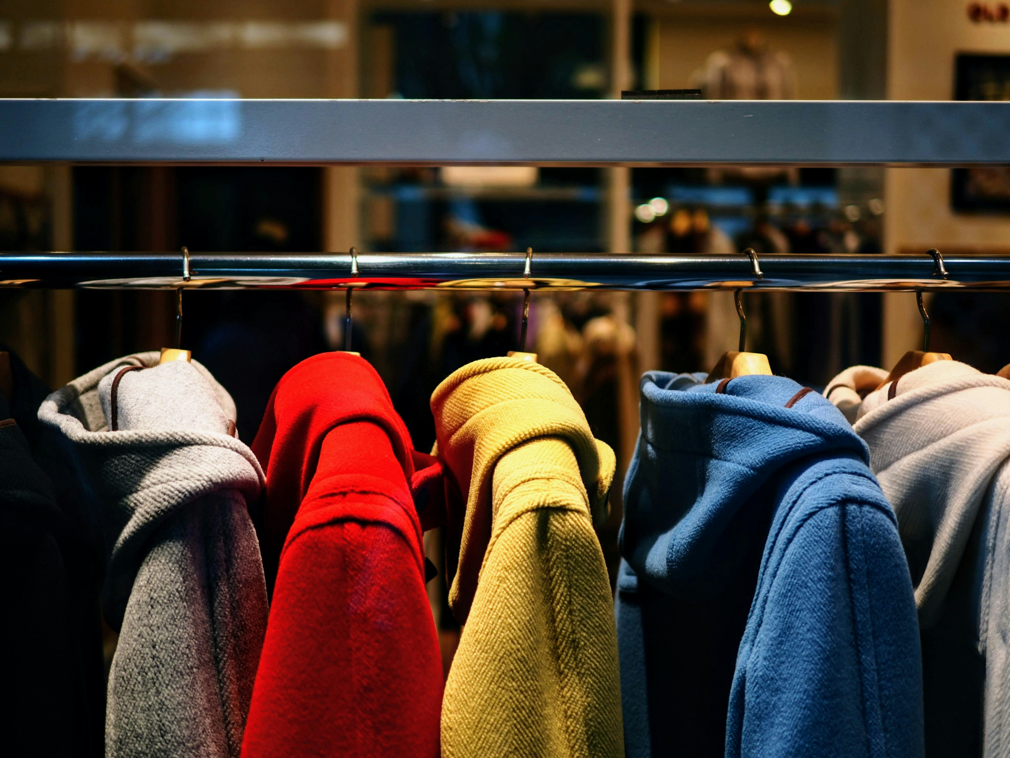 Colorful fleece and coats on a store rack inside a shop