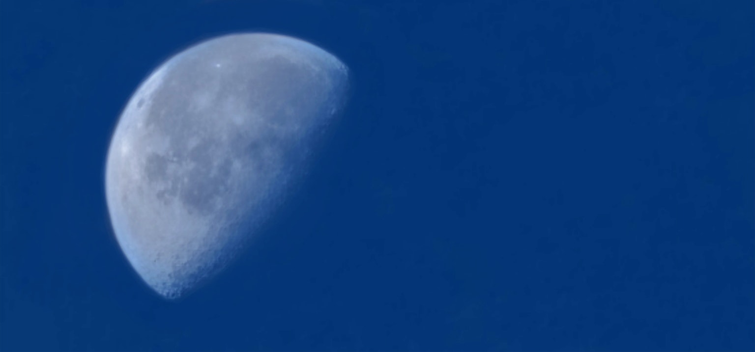 Detailed image of a crescent moon in a blue sky