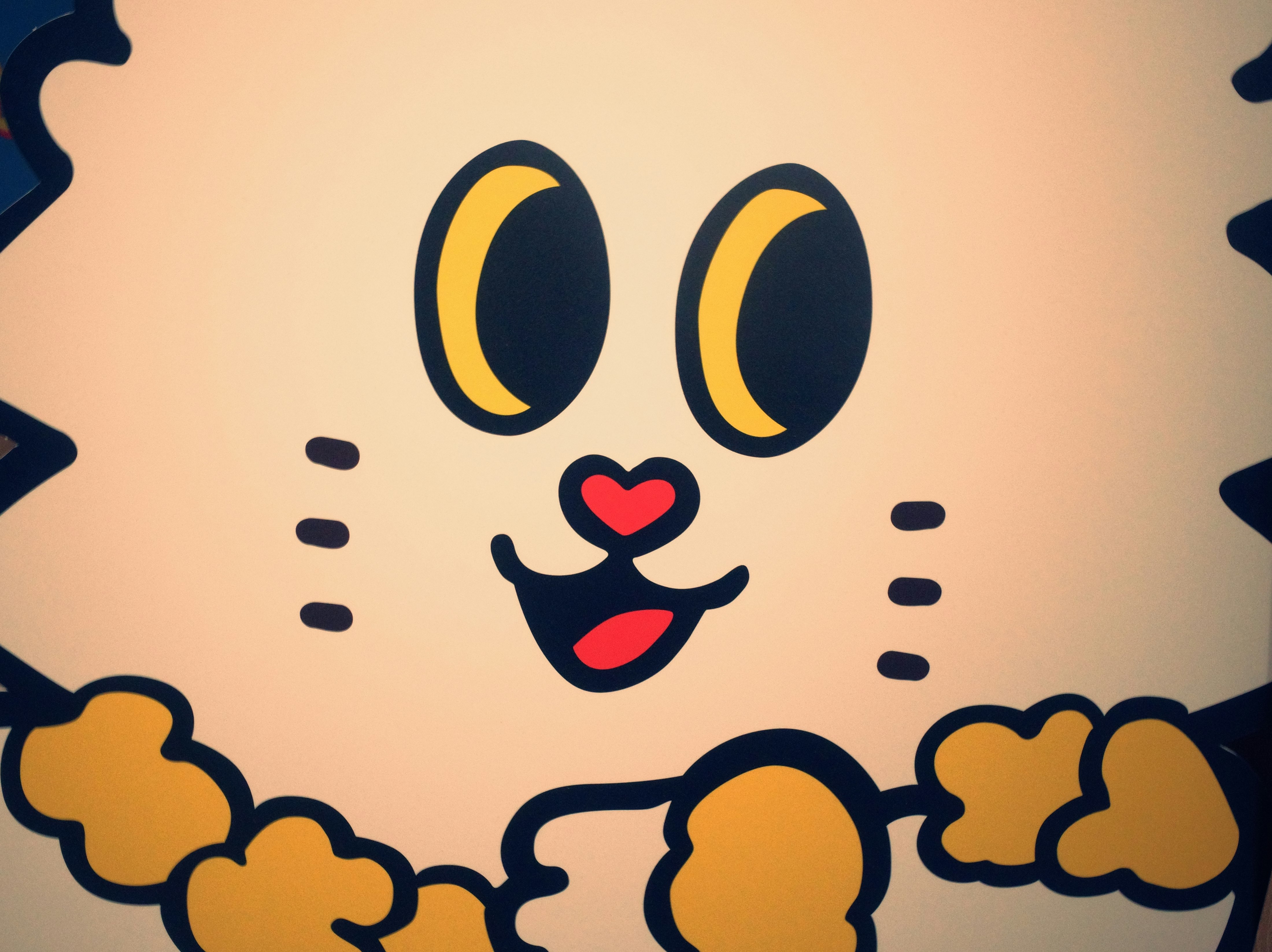にこにこしたキャラクターのイラストが描かれた壁面