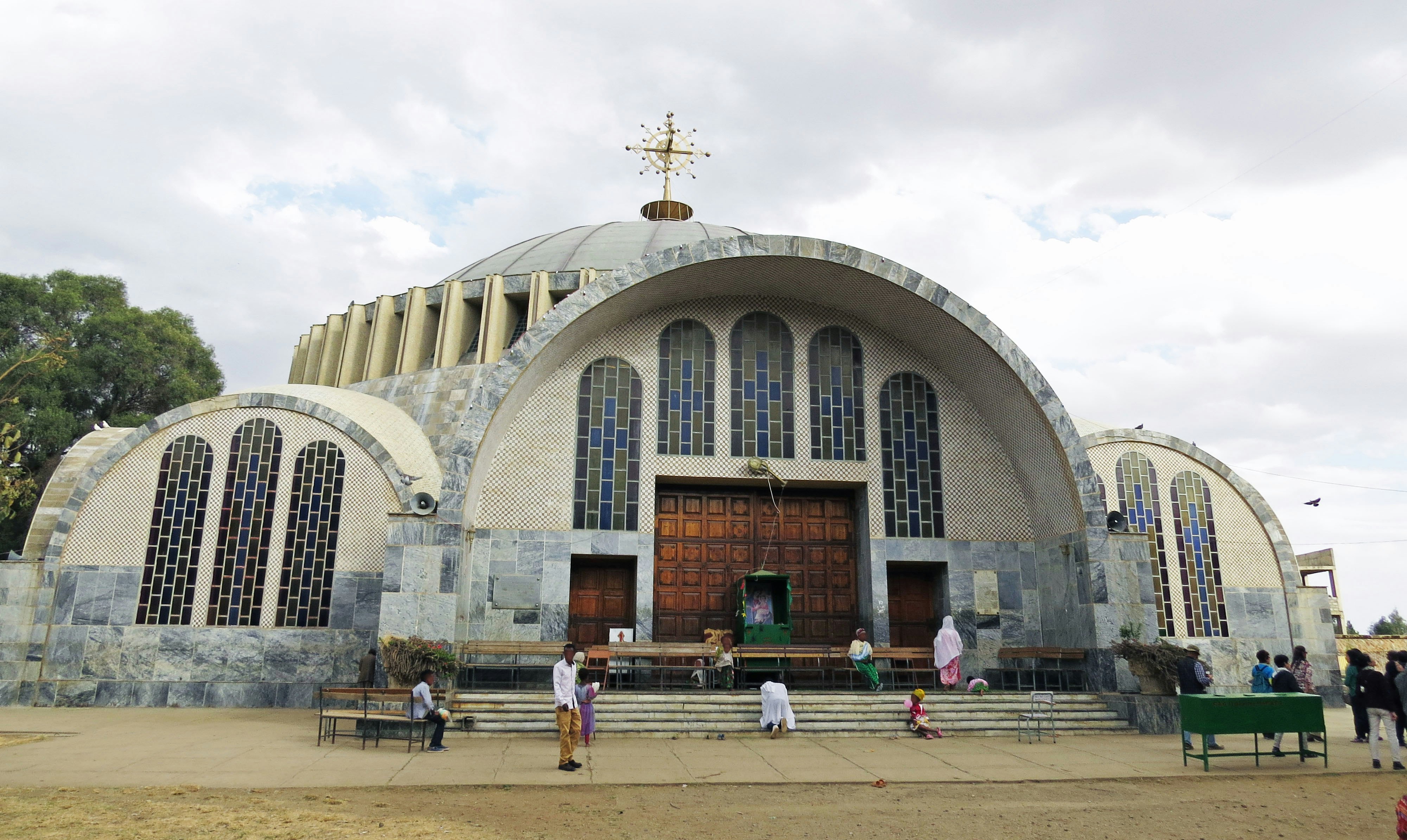 fachada de una catedral con cúpula y personas en la plaza