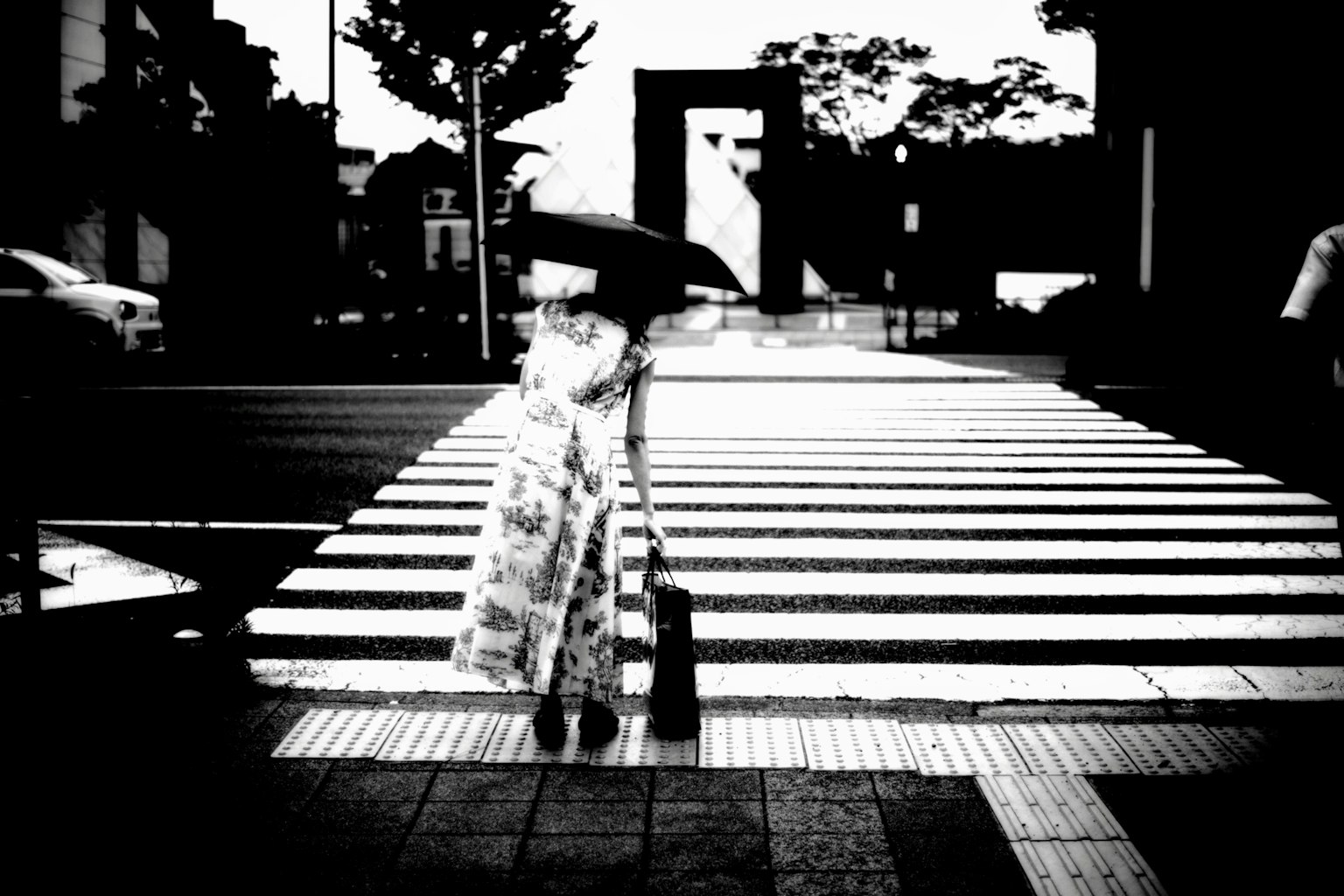 ผู้หญิงในชุดกิโมโนข้ามทางม้าลายสีขาวดำถือร่ม