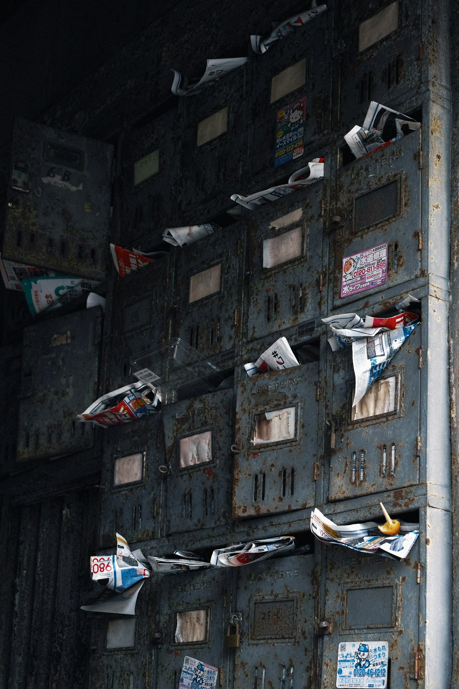Vecchie cassette postali con pacchetti di giornali sparsi