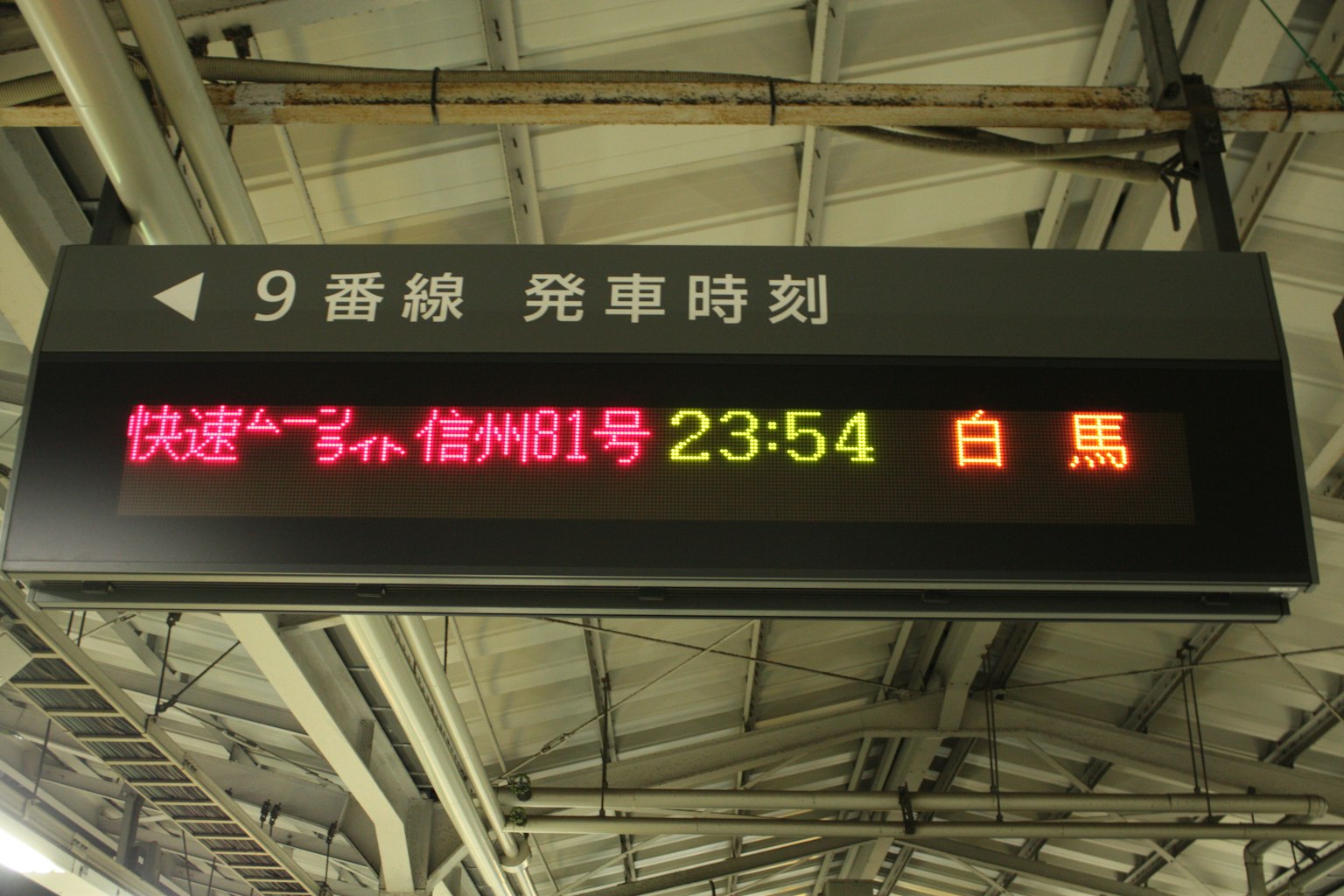 Información del tren mostrada en un tablero electrónico de estación andén 9 hora de salida 23:54 hacia Hakuba