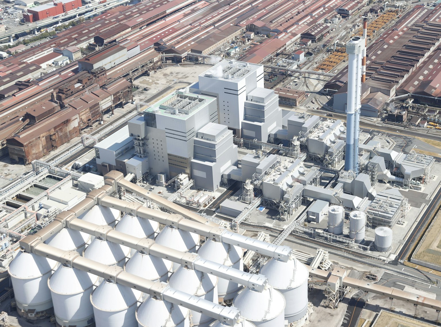 Aerial view of an industrial area featuring a factory and cylindrical silos