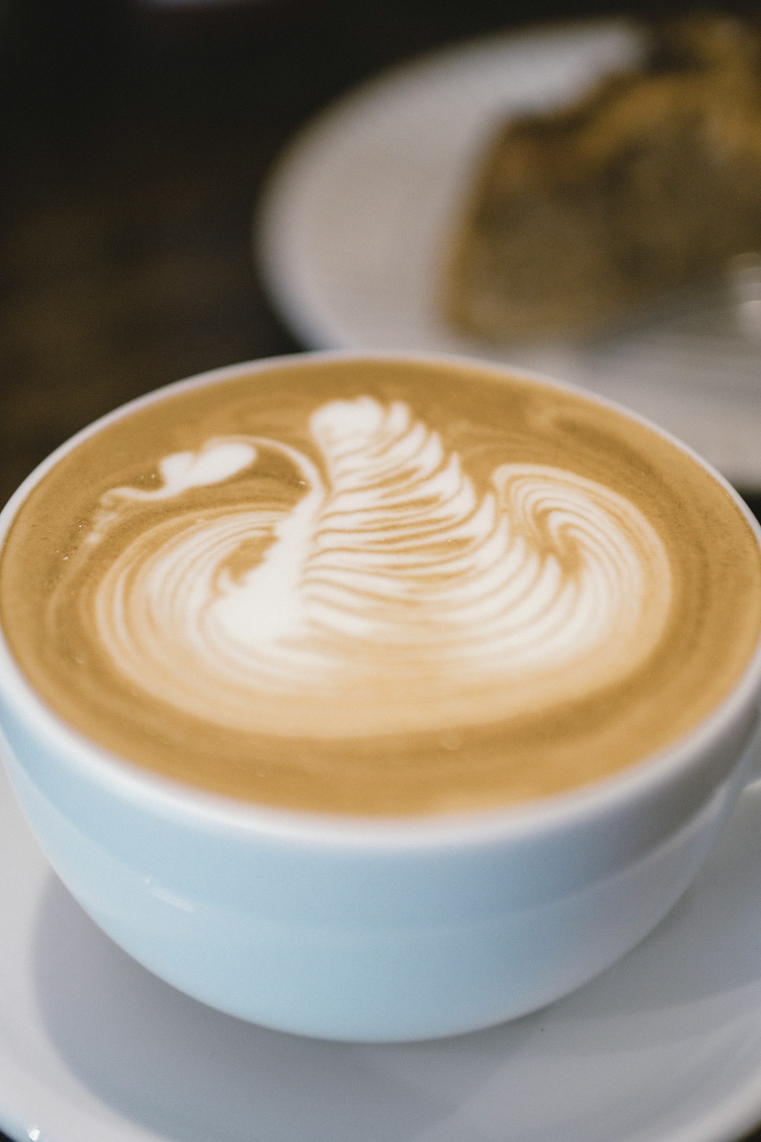Seni latte yang indah di cangkir kopi putih